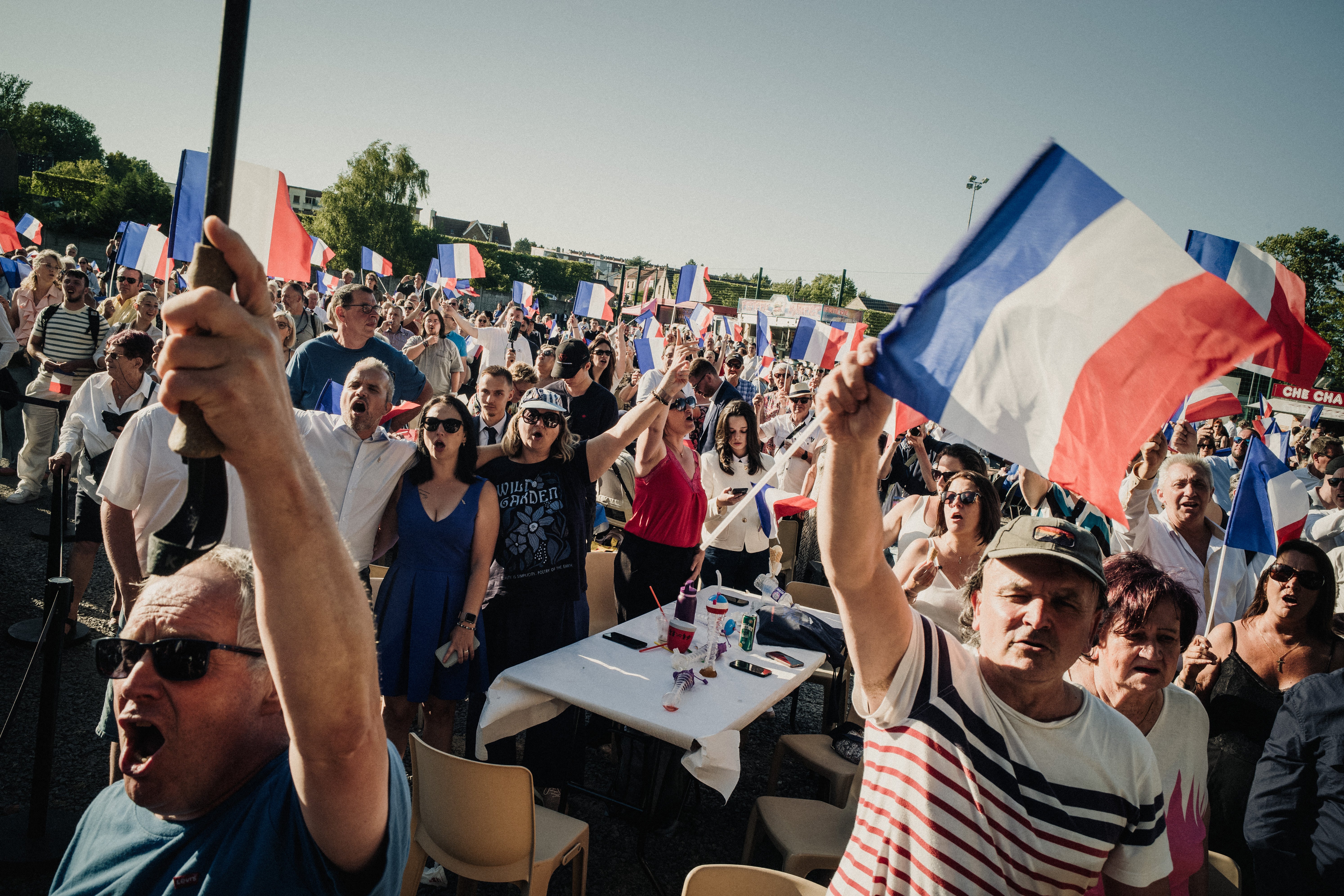 A crowd waves French flags during an event organised by the National Rally in Lievin, France on 4 July