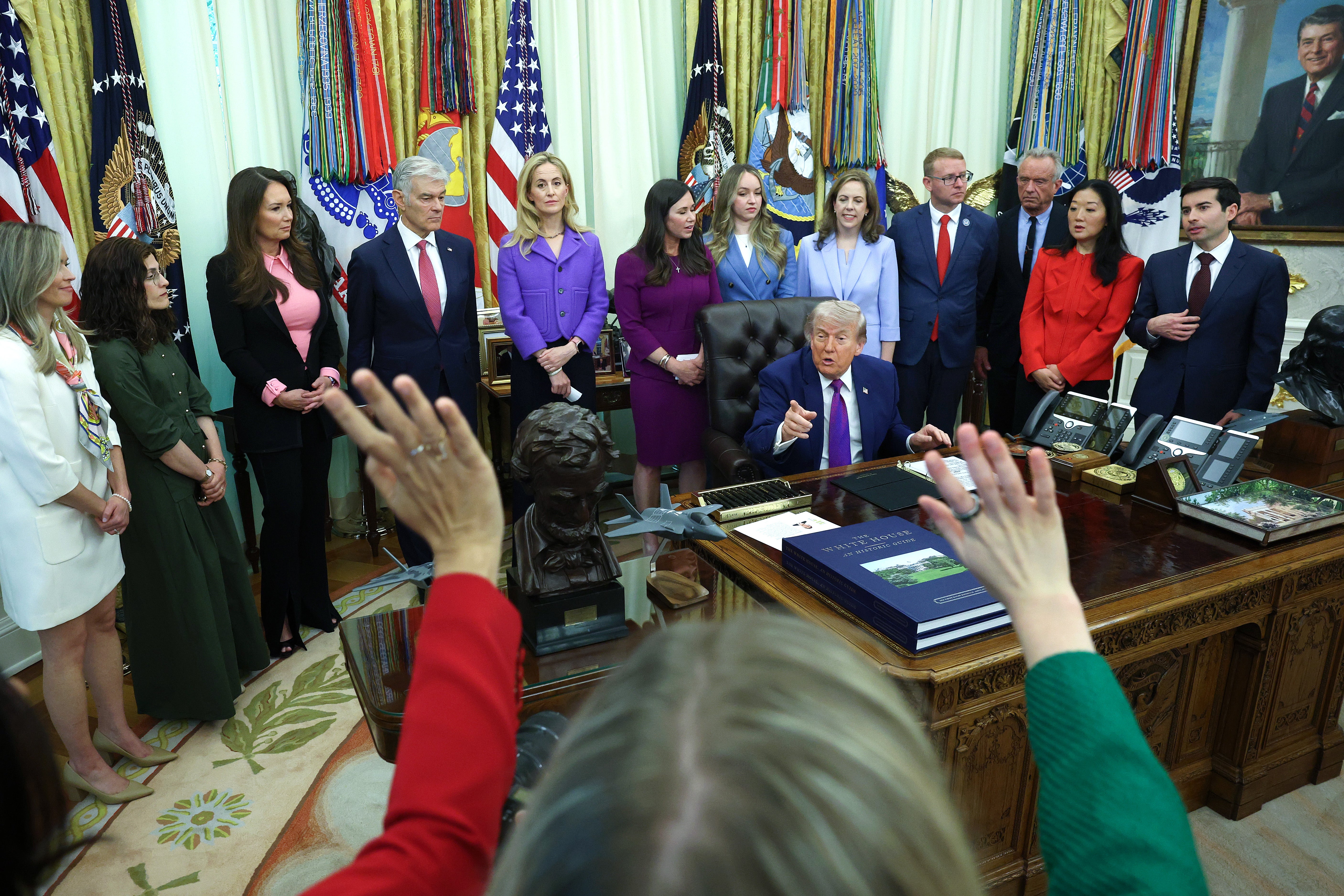 Trump seen taking questions from reporters during and event on maternal healthcare in the Oval Office on May 11