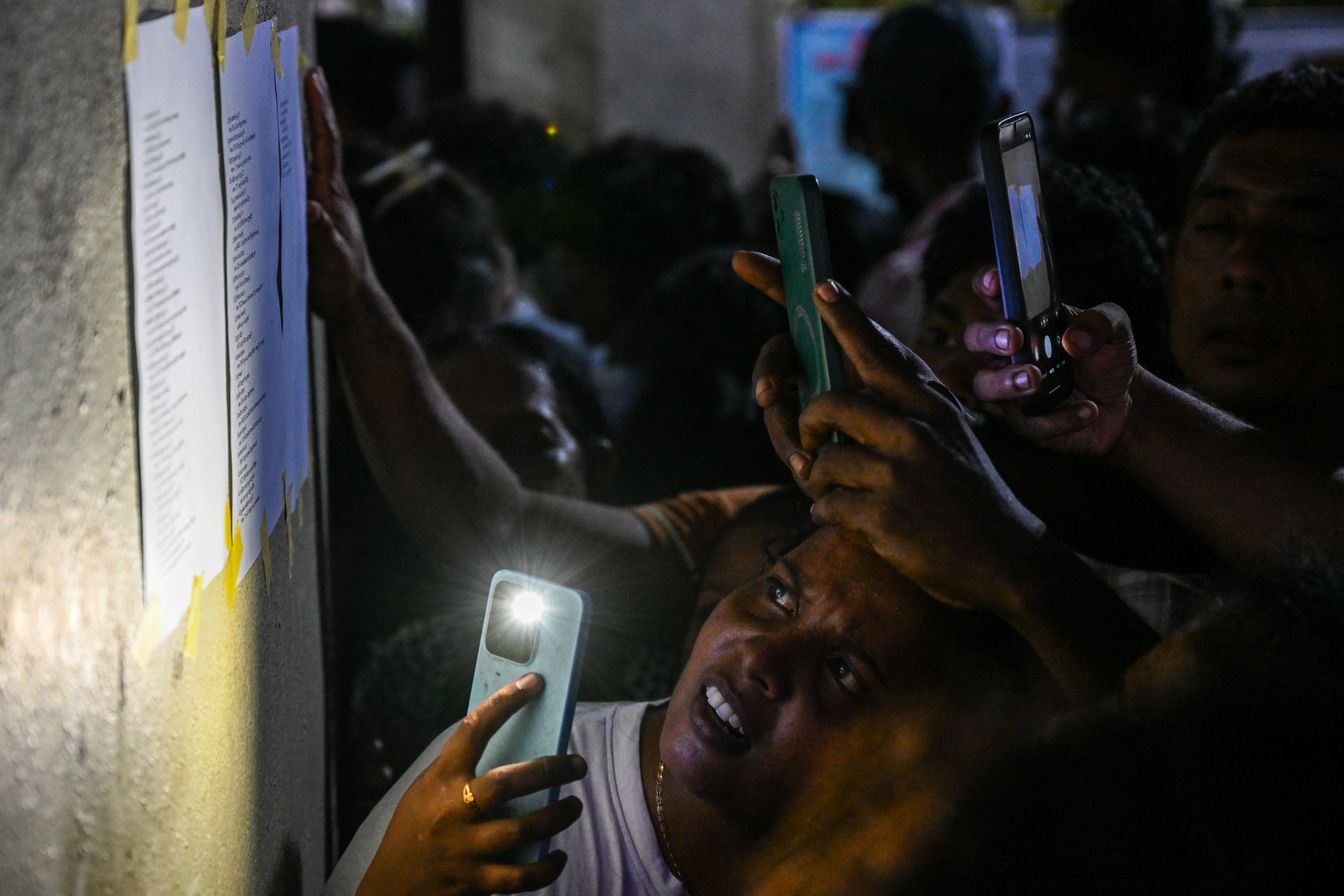 Relatives check namelists identifying victims of overnight clashes between prison inmates of two drug gangs, displayed outside a hospital in Negombo on the outskirts of Colombo