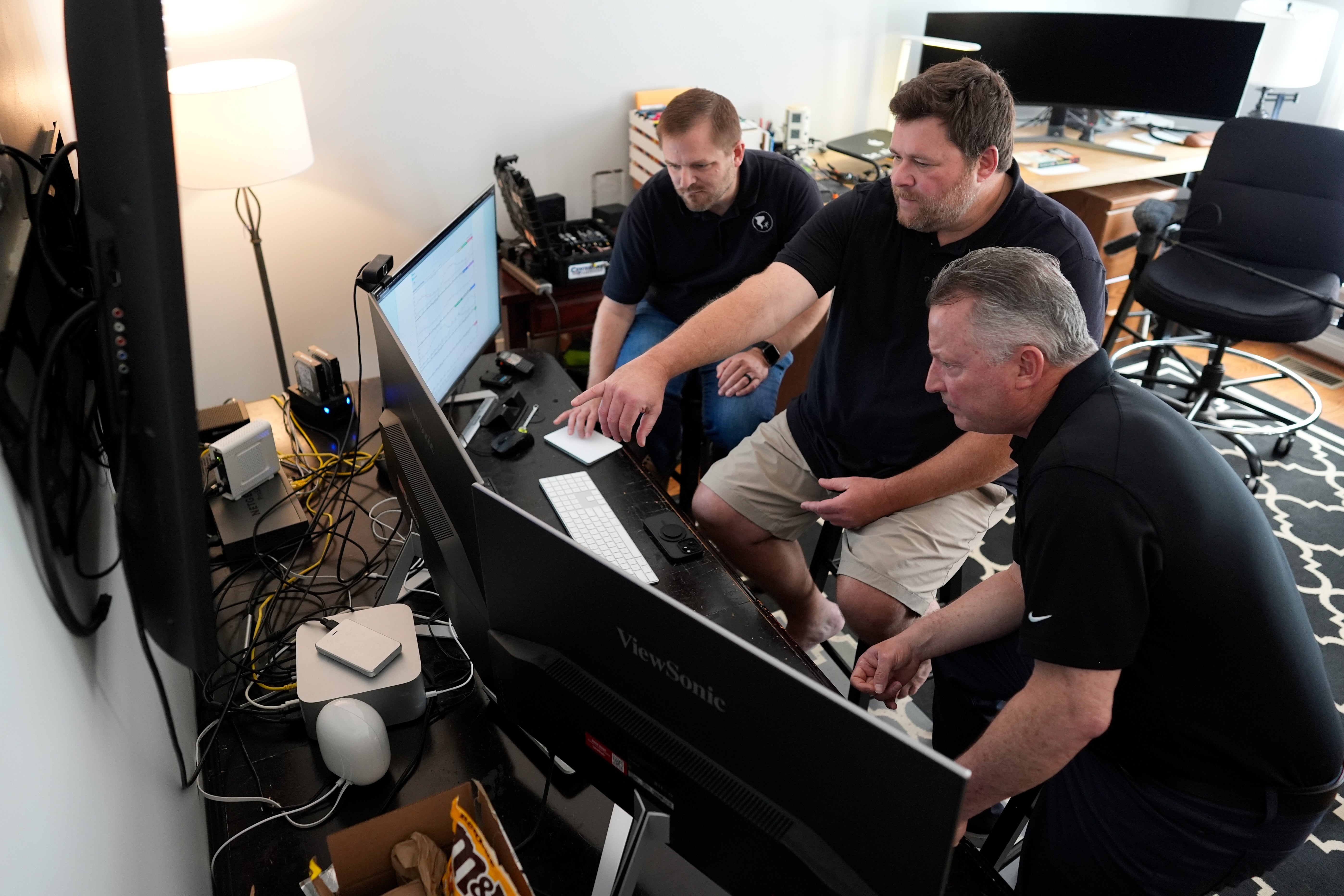 Andrew Leeper, left, Will Minkoff and Tom Johnstone, right, of Nashville Severe Weather, look over weather data Monday, April 20, 2026, in Nashville