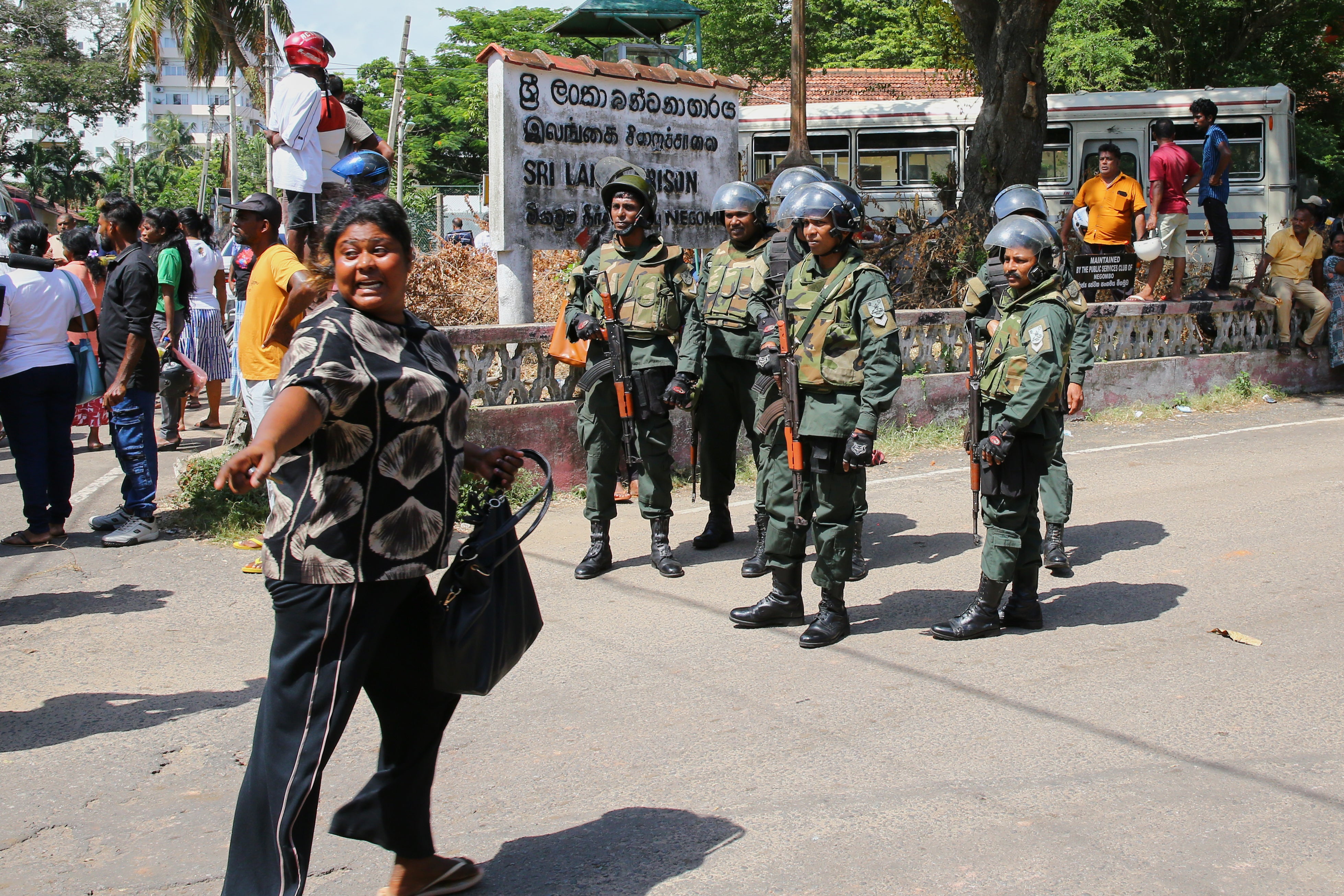 Security personnel stand guard outside a prison where deadly clashes broke out on Sunday, in Negombo