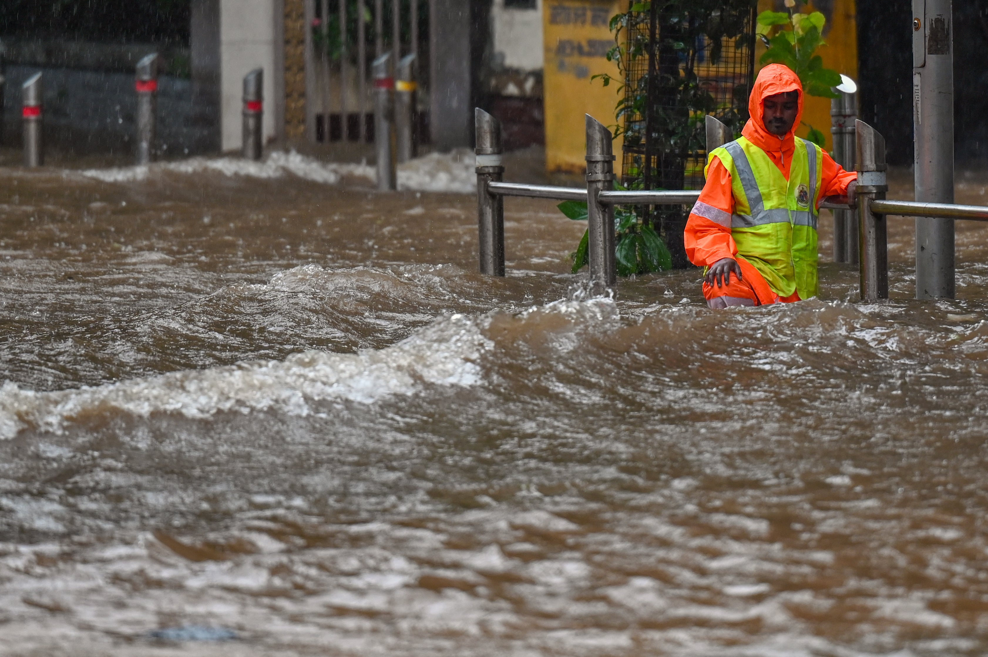 A civic authority worker stands on a flooded street during heavy rain showers in Mumbai (AFP/Getty)