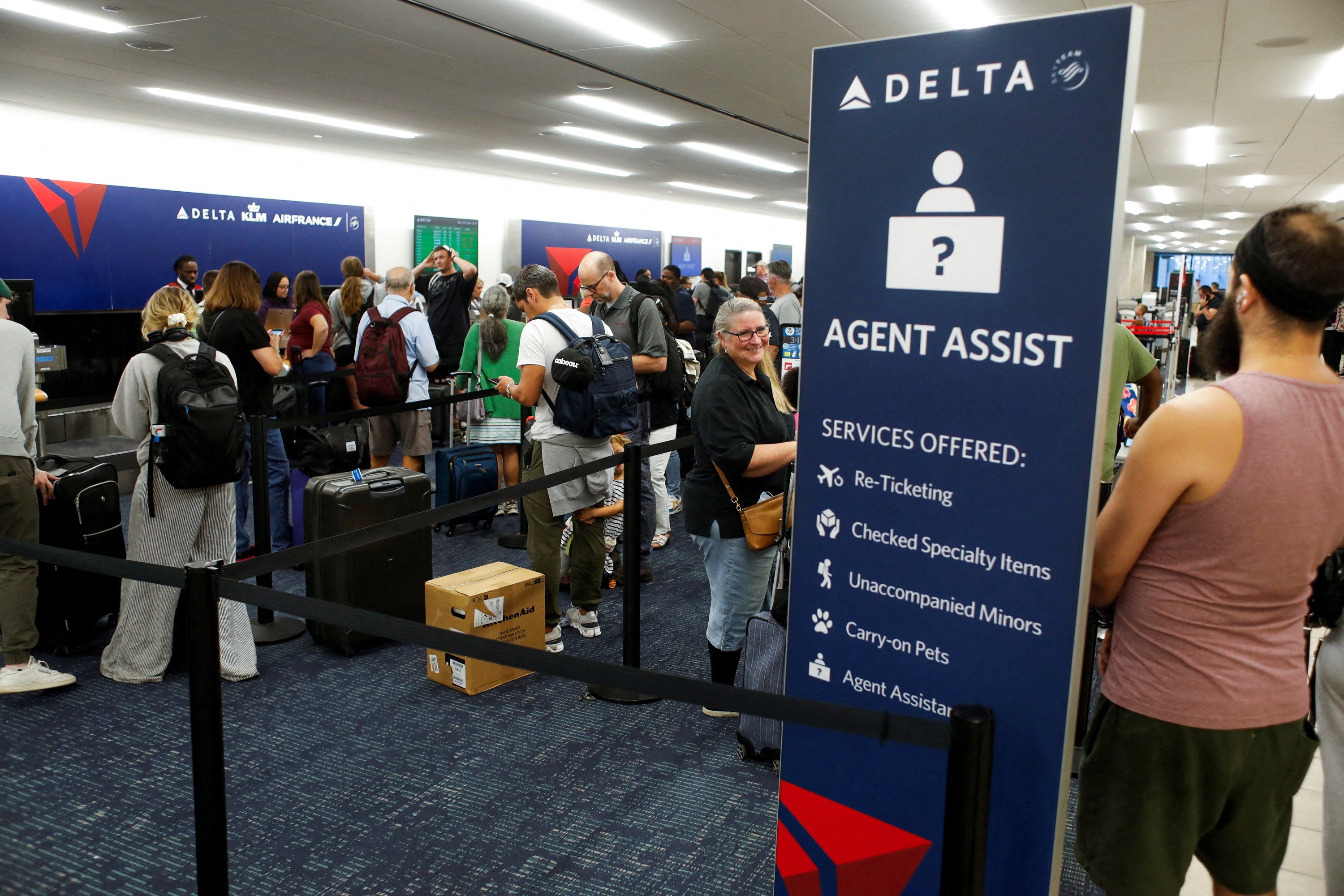 Airline passengers wait in line at the Delta, KLM, and Air France ticketing counters