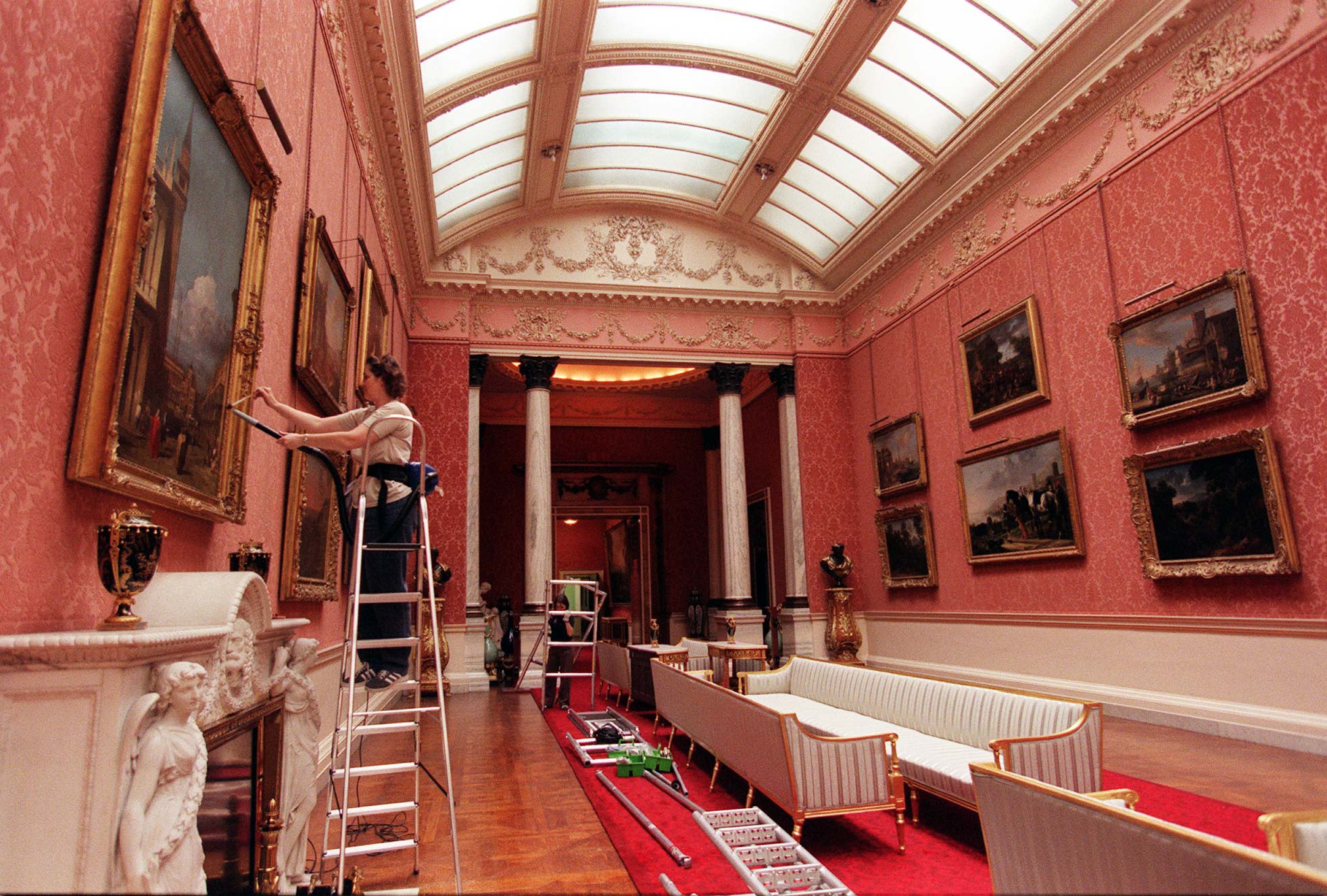 A cleaner dusts the frames in the Picture Gallery on 31 July 1998