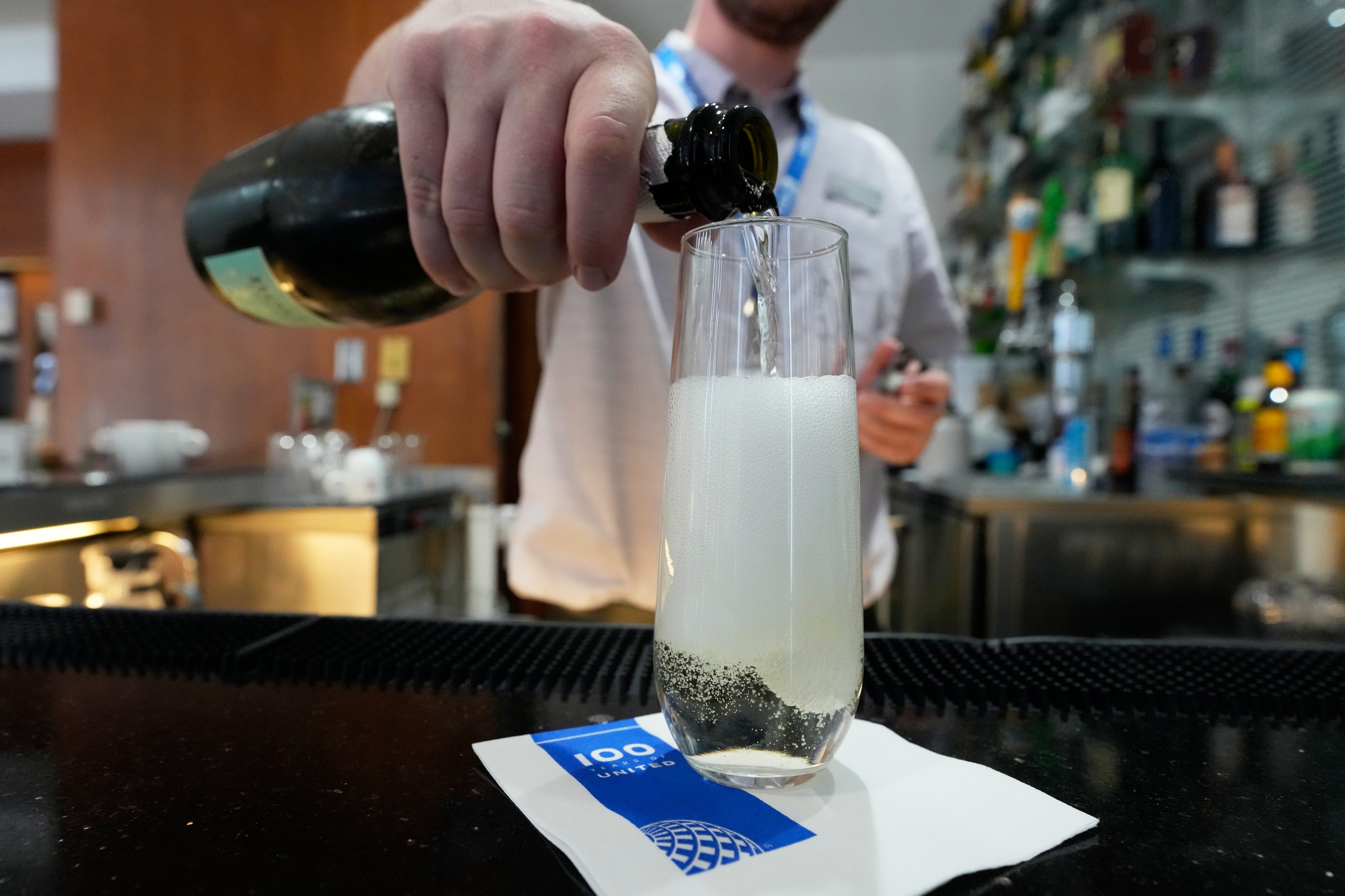 A bartender pours a glass of sparkling wine at the United Club lounge, Monday, June 29, 2026, in Minneapolis