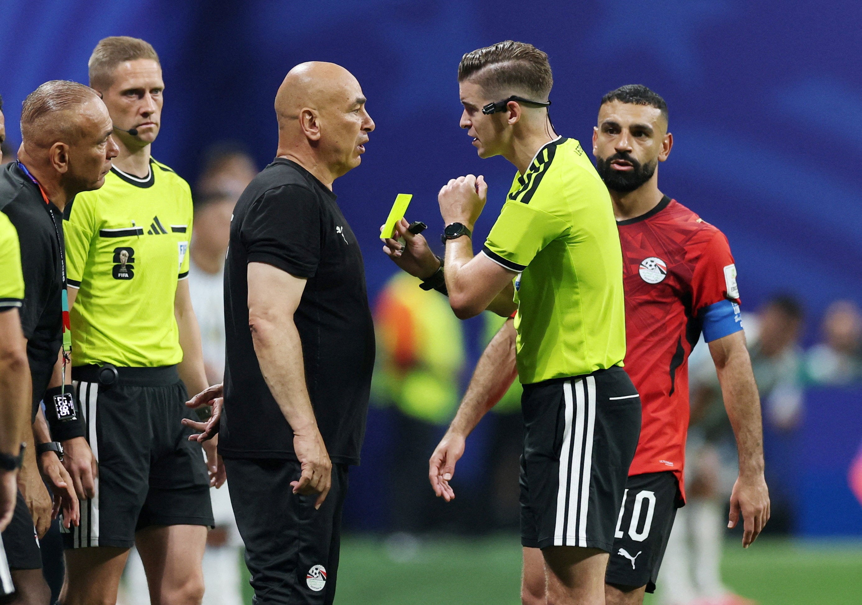 Egypt coach Hossam Hassan is shown a yellow card by referee Francois Letexier