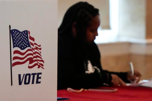 A Fulton County staff member works as people vote in a runoff election, Tuesday, June 16, 2026, in Atlanta