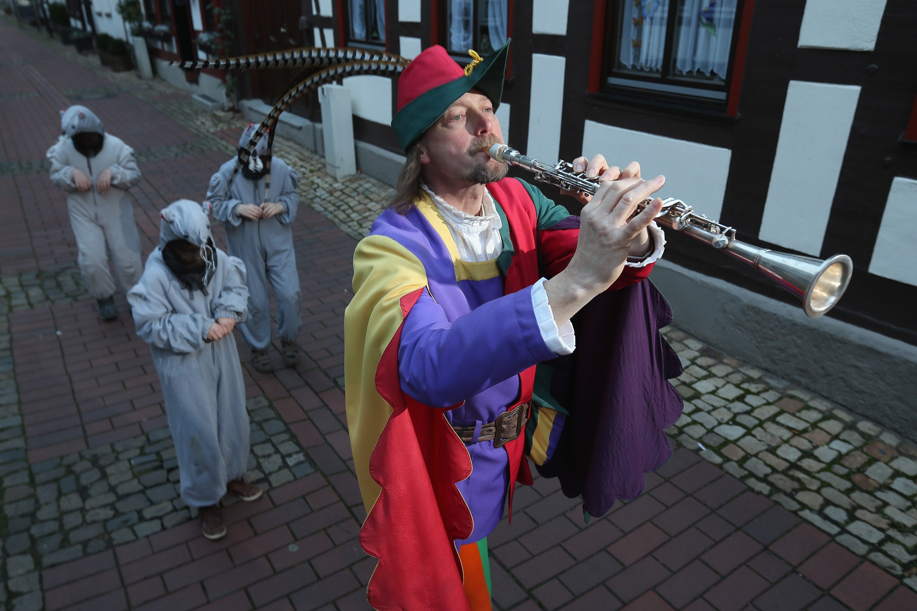The Pied Piper of Hamelin, actually city tourism employee Michael Boyer, leads local children dressed as rats through a quiet street on 19 November 2012