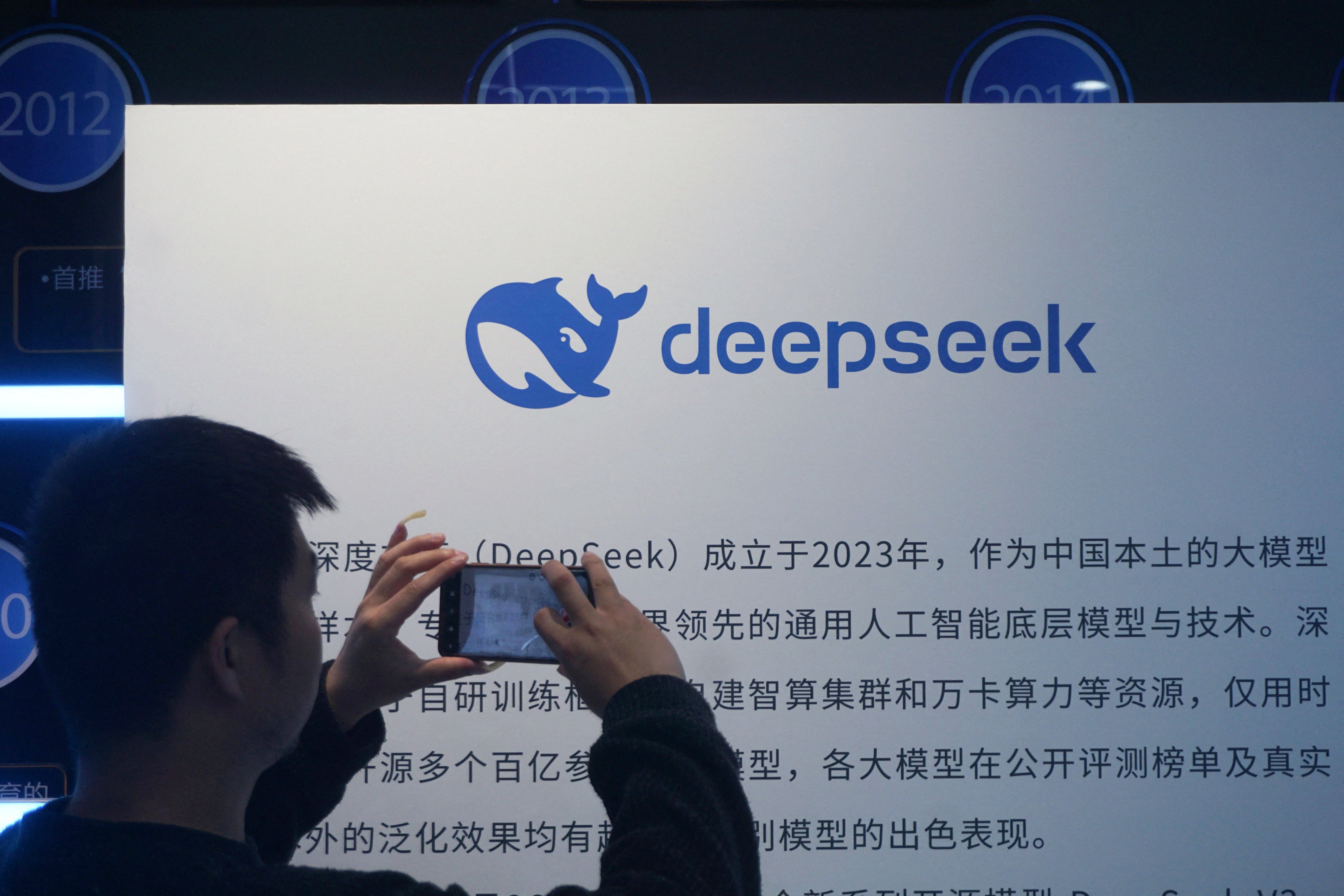 A man takes photos of a DeepSeek display at a shopping mall in Hangzhou, in China's eastern Zhejiang province on 23 April, 2026 (AFP/Getty)