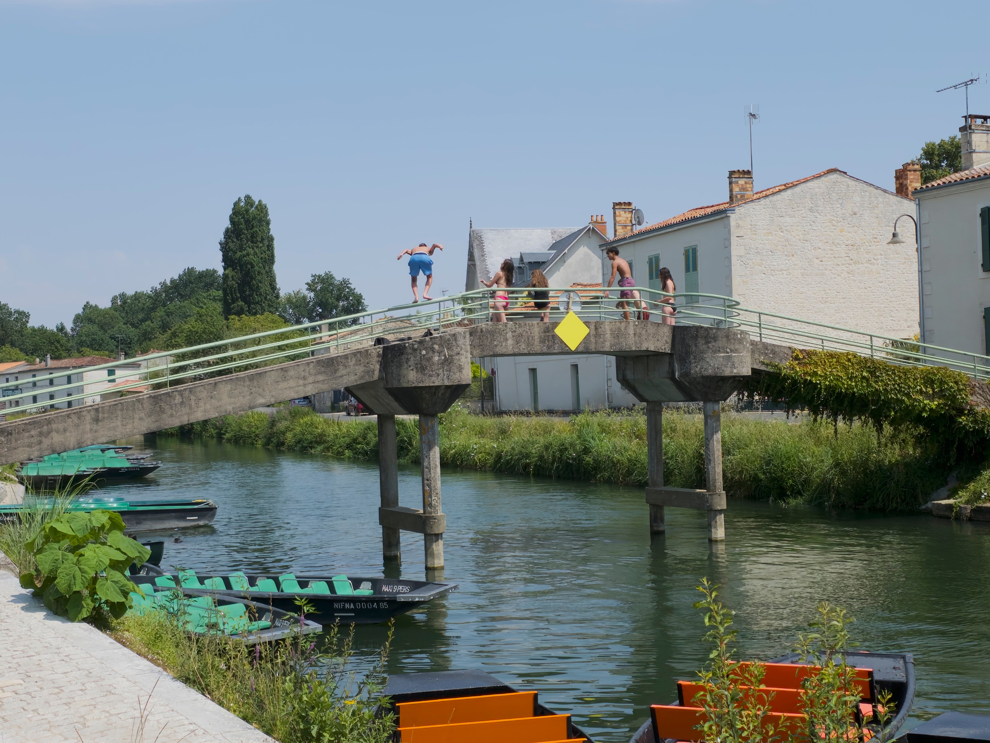Local children jumping off a bridge at Coulon in France