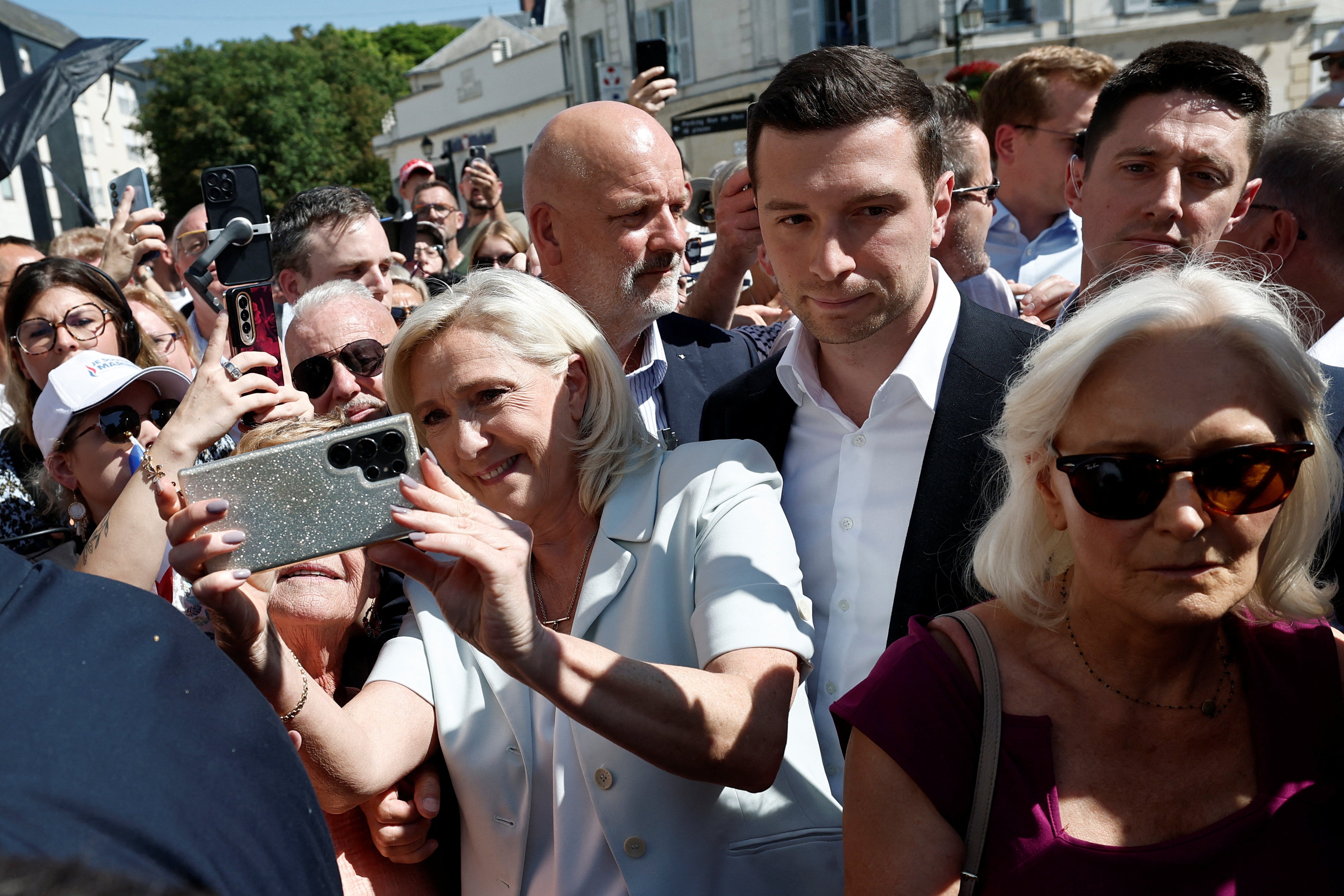 Marie-Caroline Le Pen, her sister and RN delegate for Sarthe, surrounded by supporters and journalists during a visit at a market in La Fleche