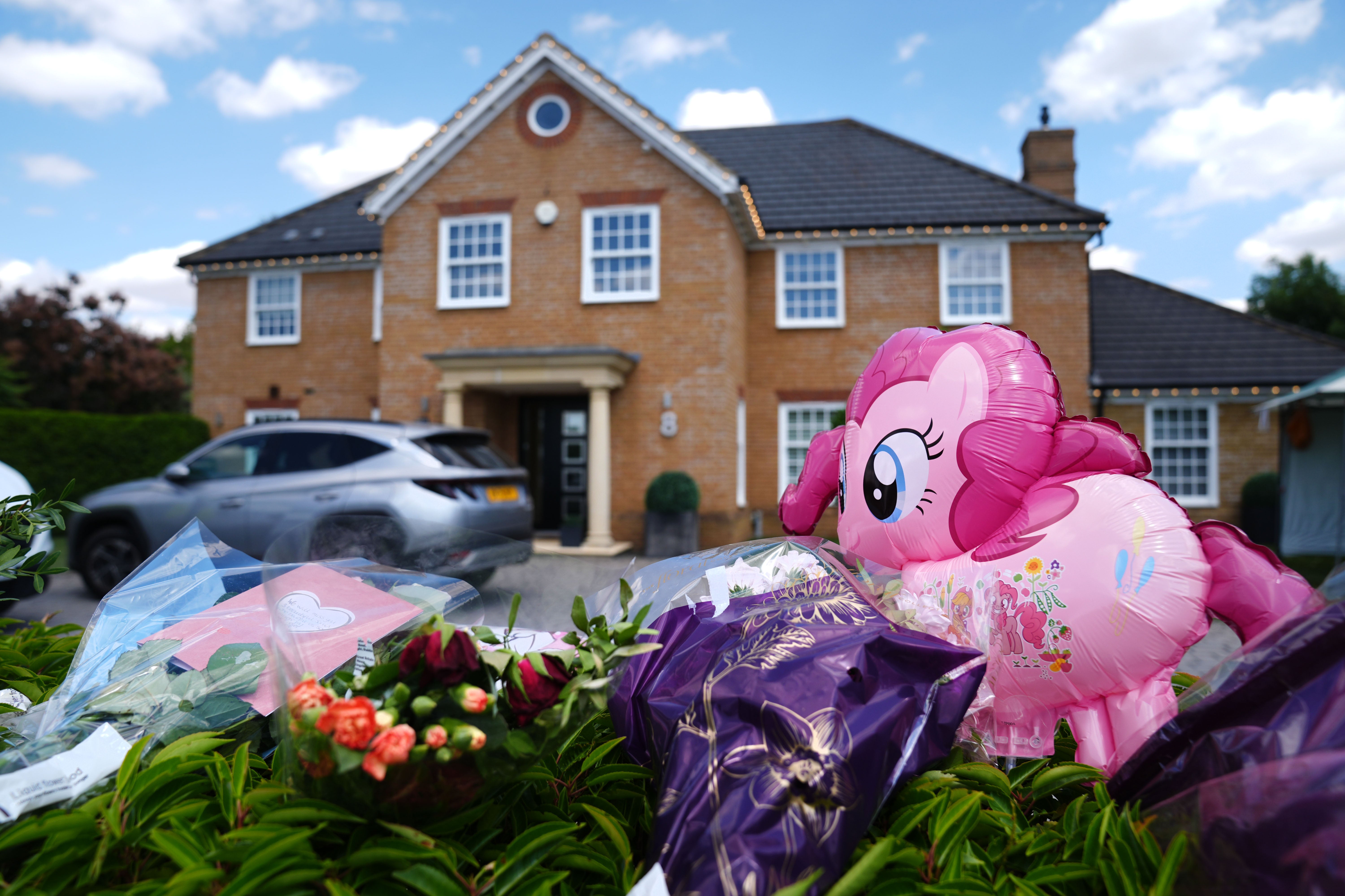 Flowers and balloons left outside the house in Great Denham (PA)