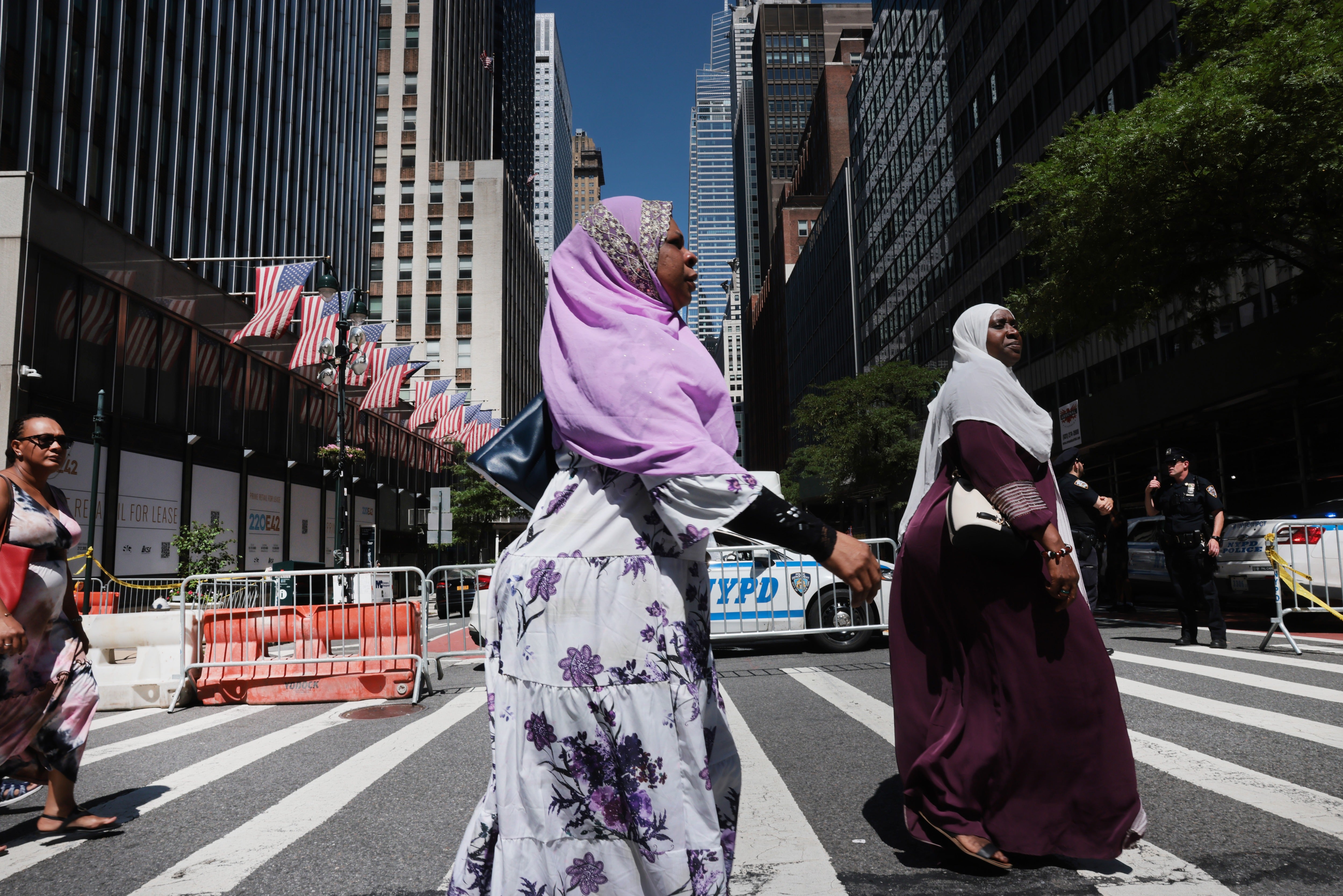 Two women walk past a closed section of 42nd Street beside the former Pfizer headquarters building on Wednesday