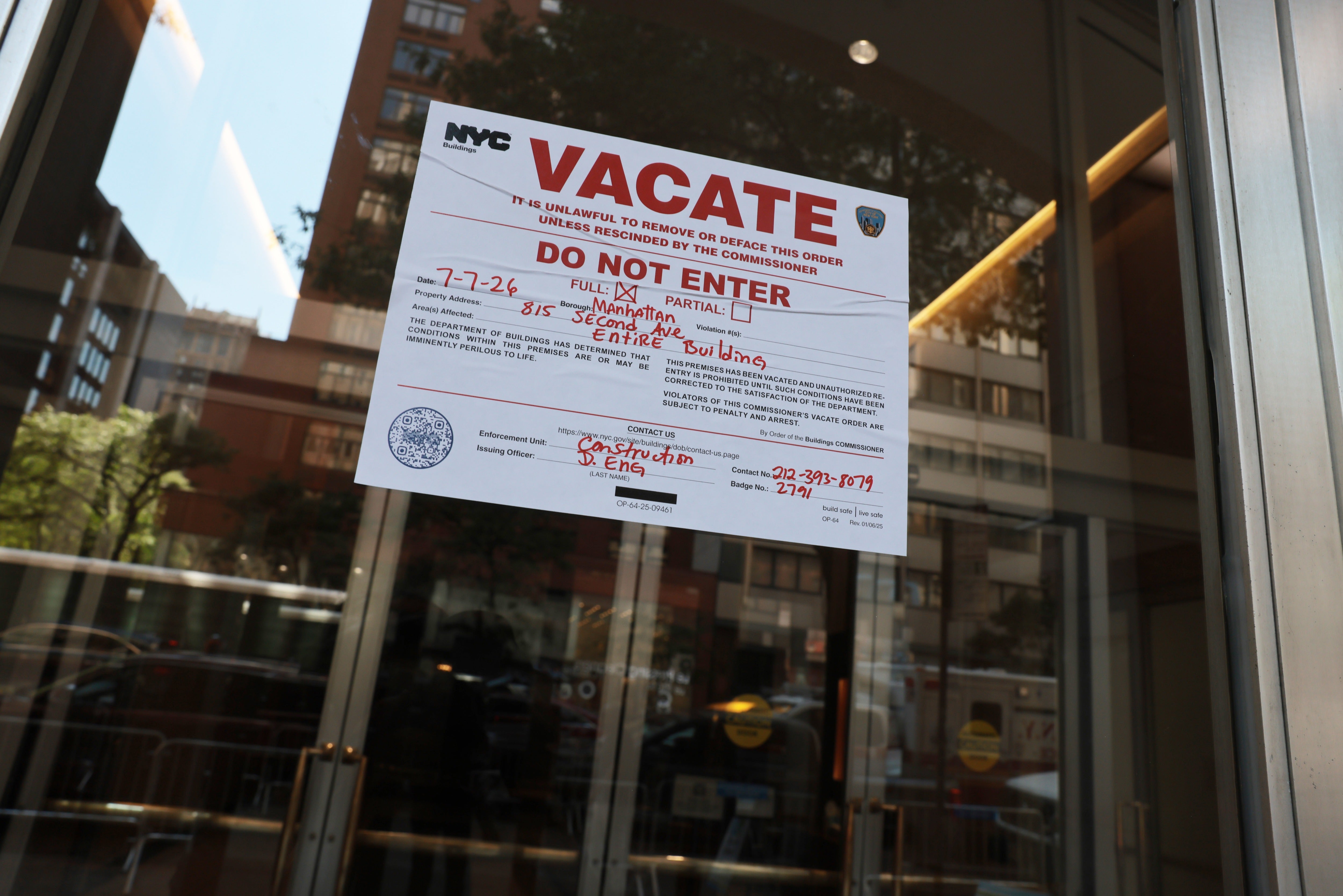 A 'vacate' notice is displayed on a door inside of a church across from the former Pfizer headquarters building on Wednesday