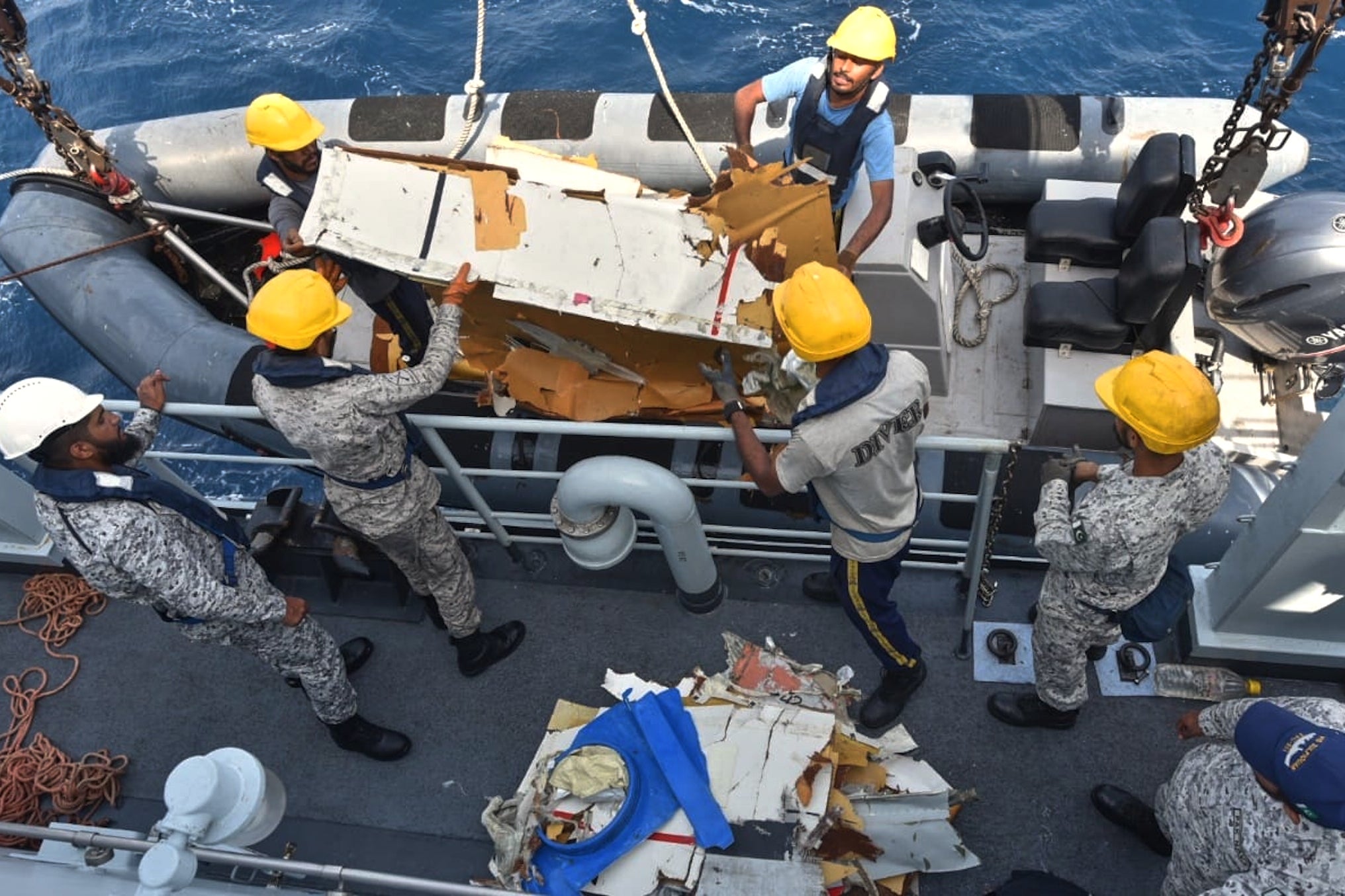 Pakistan Navy personnel shift the wreckage of a cargo plane of the private carrier K2 Airways into a naval ship