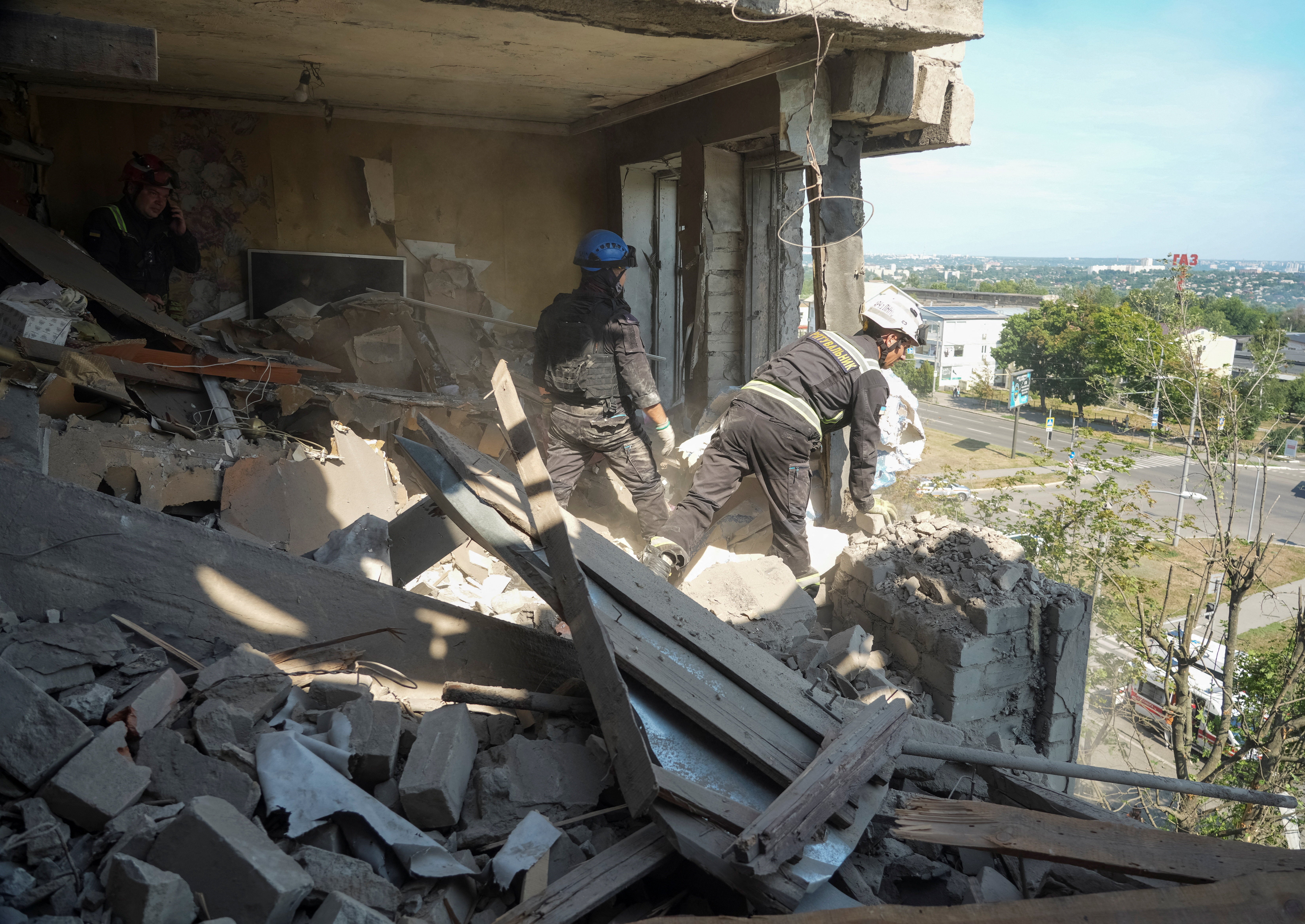 Emergency responders inspect the site of an apartment building hit by a Russian missile strike, amid Russia's attack on Ukraine, in Kharkiv, Ukraine July 8, 2026.
