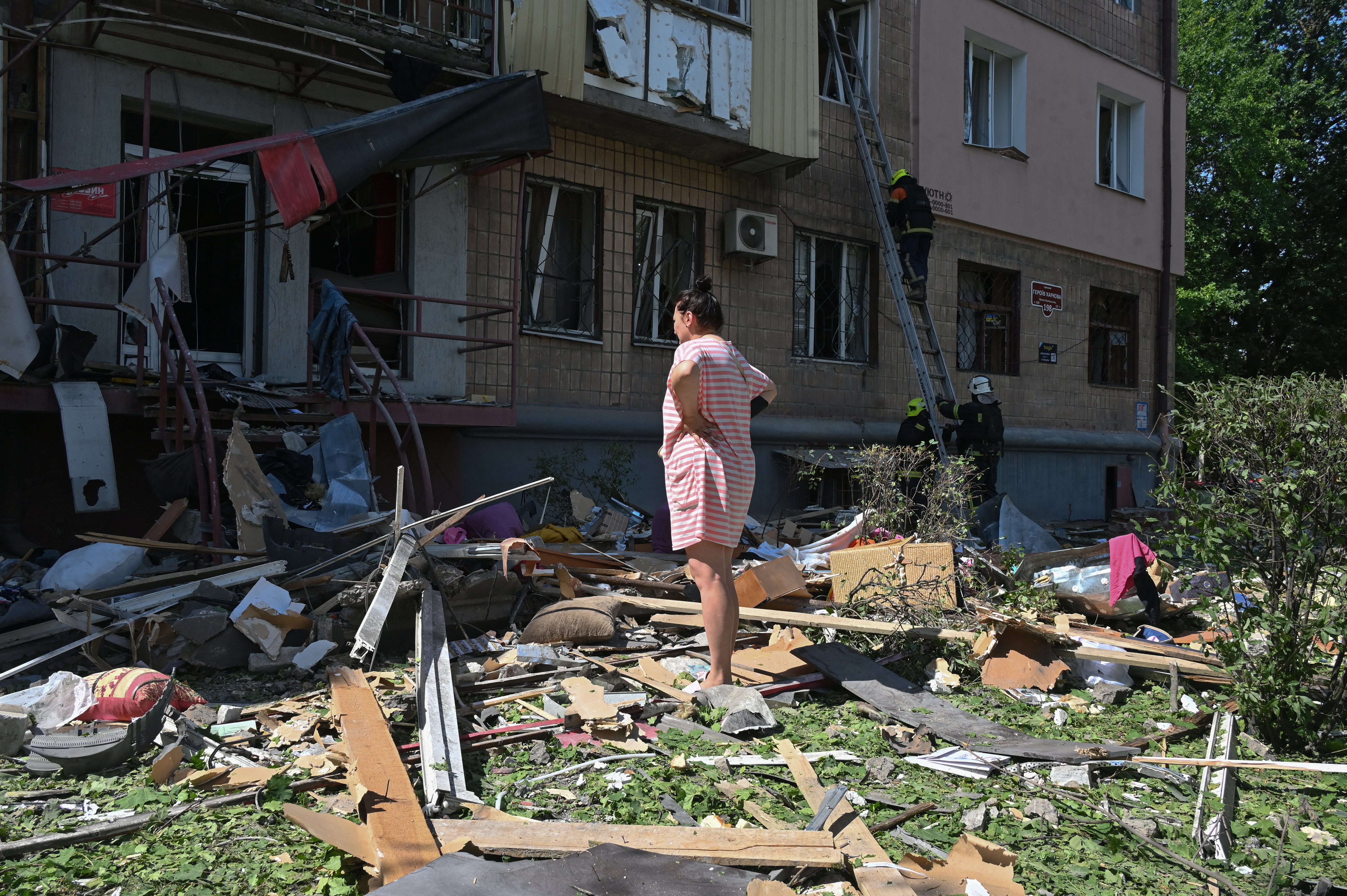 A local resident stands in front of a multistorey residential building damaged following a Russian missile strike in Kharkiv on July 8, 2026, amid the Russian invasion in Ukraine.