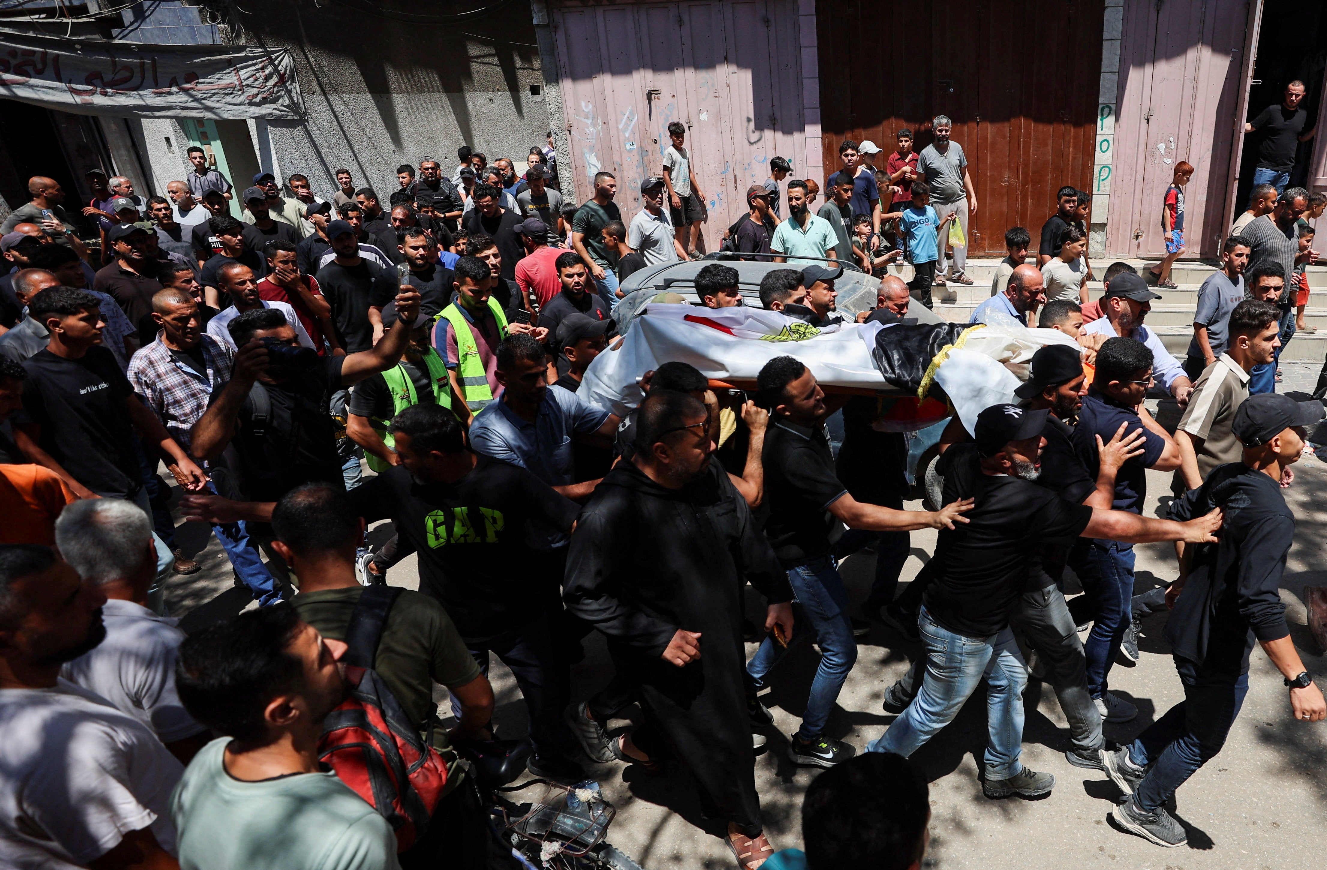 Mourners carry the body of Palestinian man Mohammad al-Waheidi, who worked for the Egyptian Relief Committee and was killed in an Israeli strike on Tuesday, during his funeral, in Gaza City, July 8