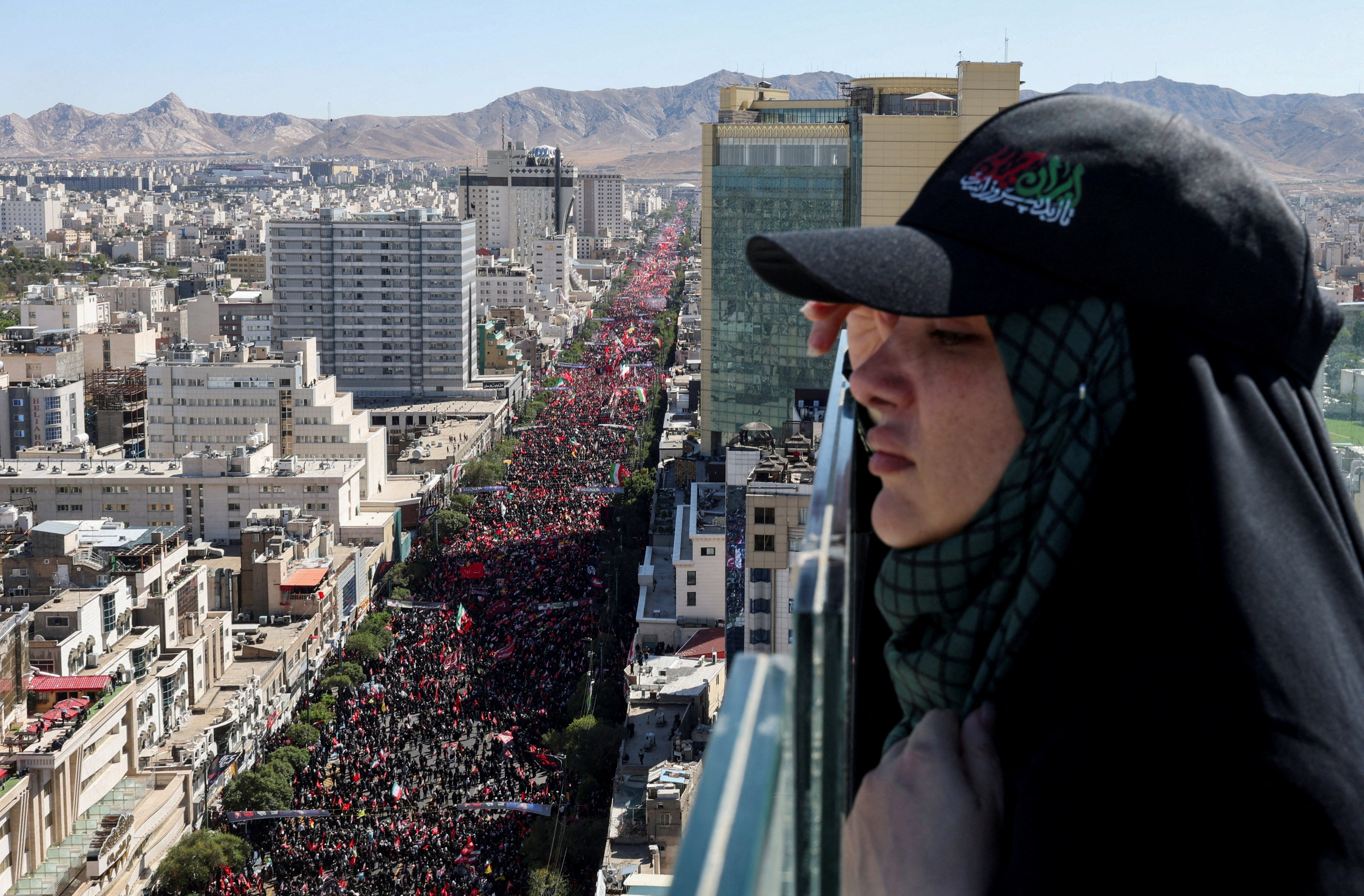 A woman looks on, as mourners gather on the day of the burial of Khamenei (Reuters)