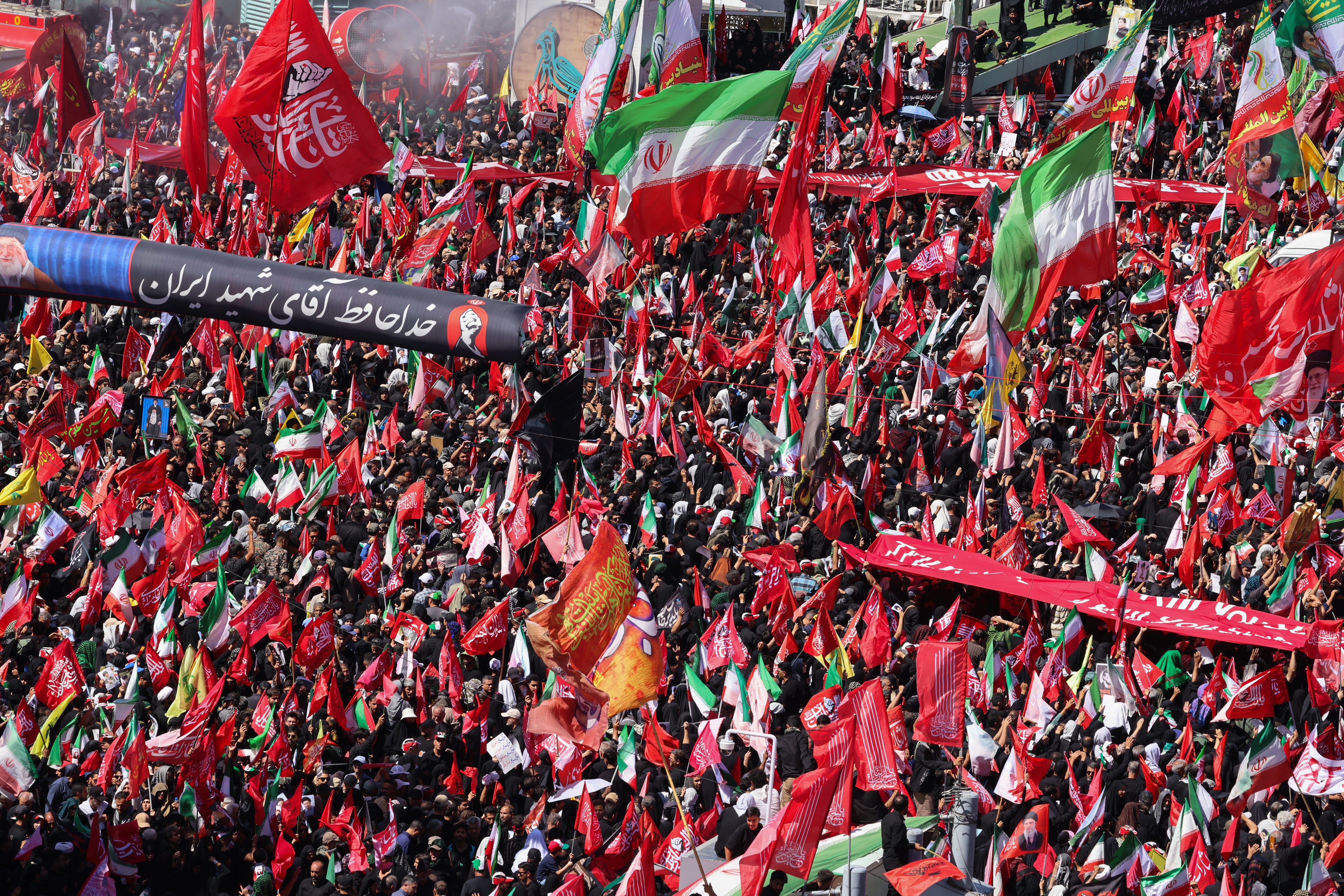 Mourners march with flags and banners during a funeral procession for Iran's slain supreme leader Ali Khamenei