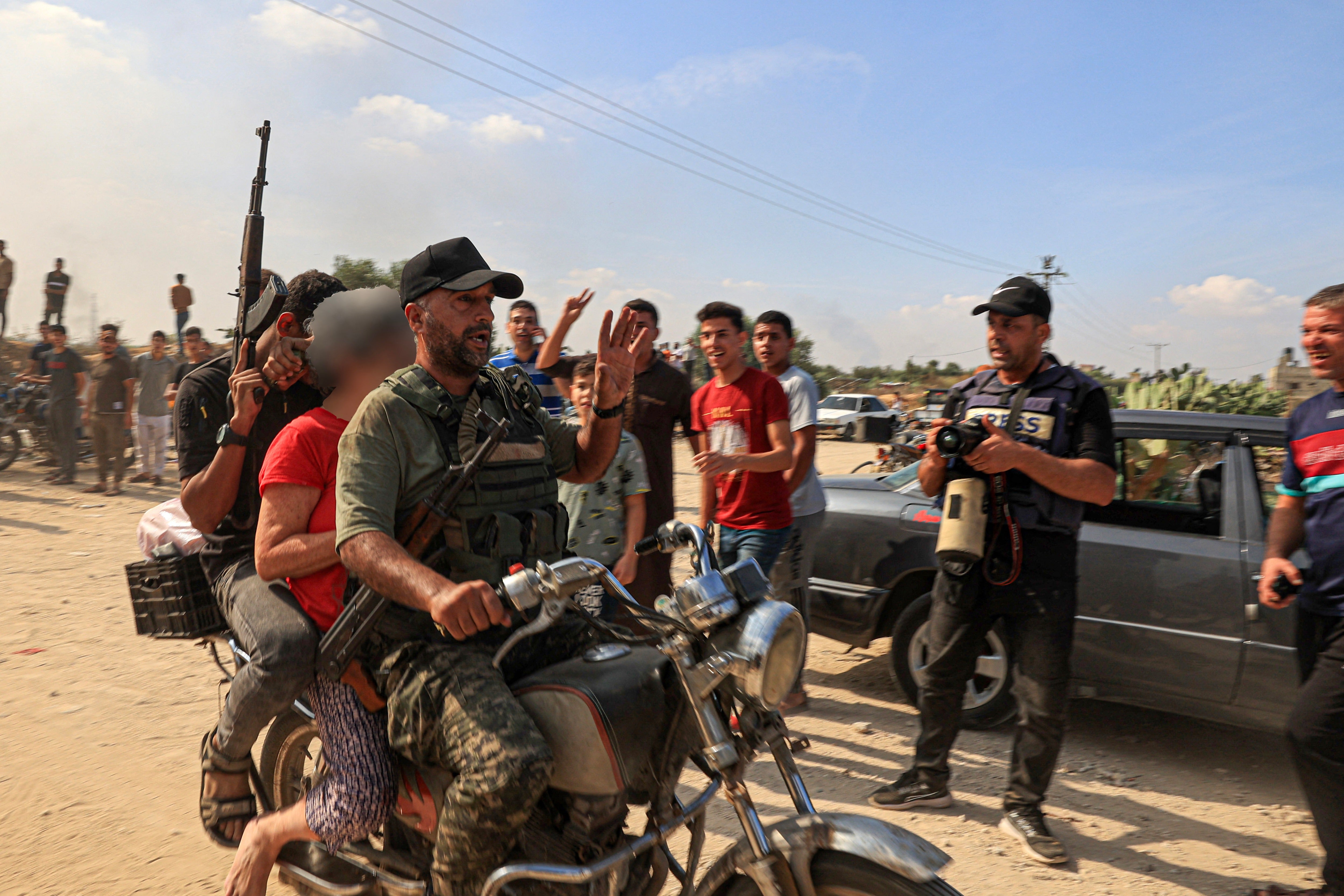 Palestinian militants transport a reportedly captured Israeli woman by motorcycle, in Khan Yunis in the southern Gaza Strip.