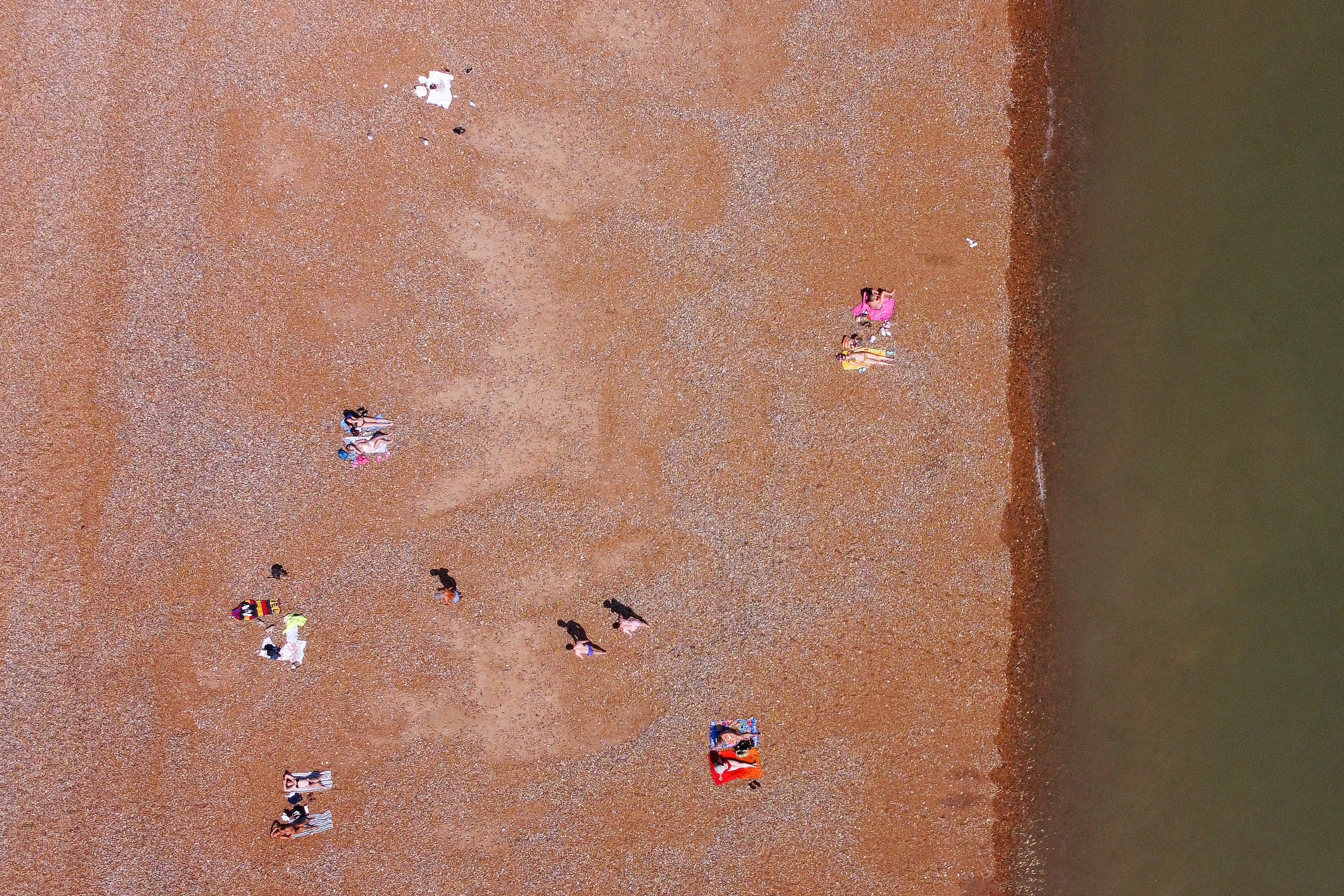 People sunbathe in Hastings as the UK is gripped by another heatwave (AFP/Getty)