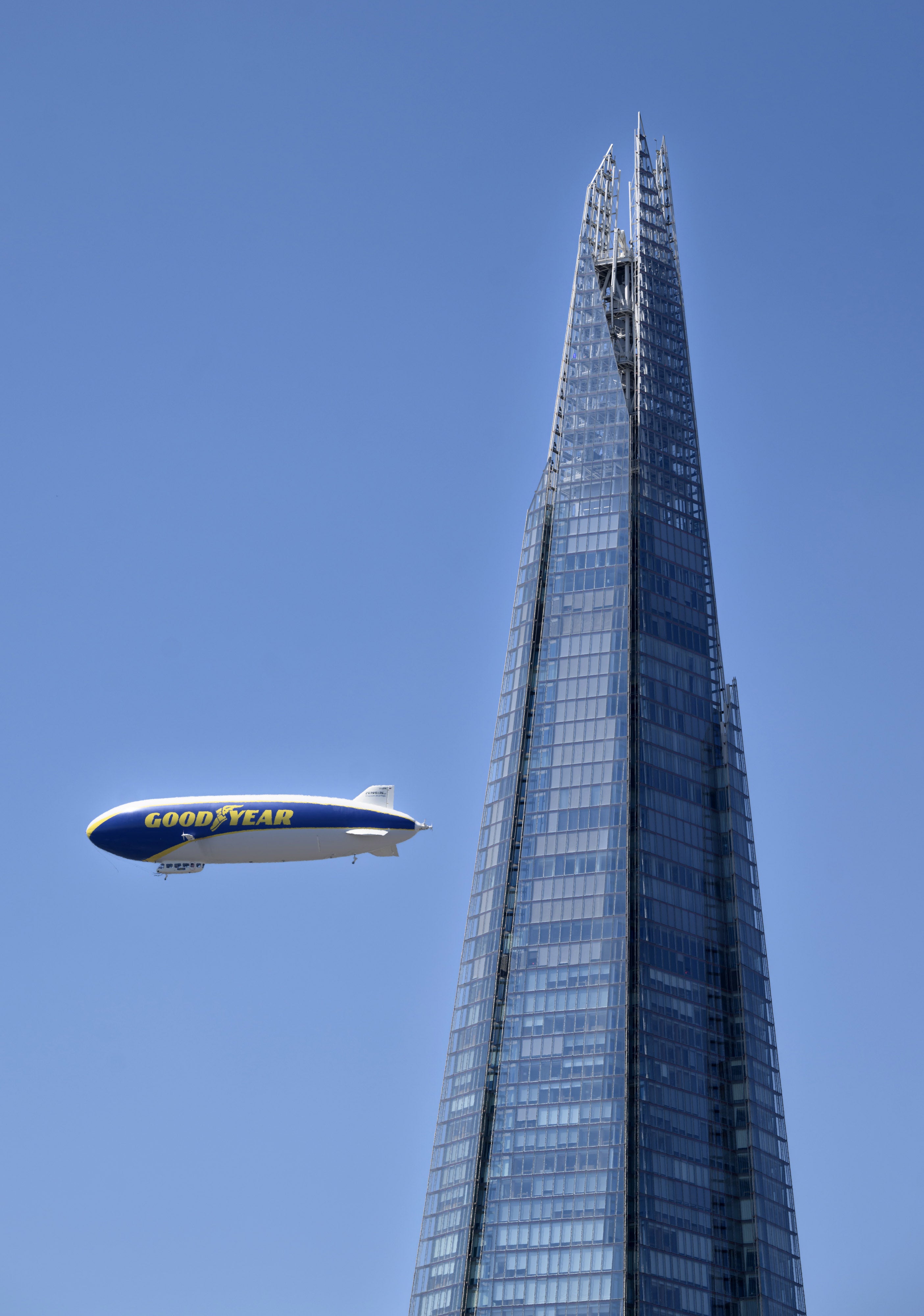 The Goodyear Blimp flying over The Shard in London.