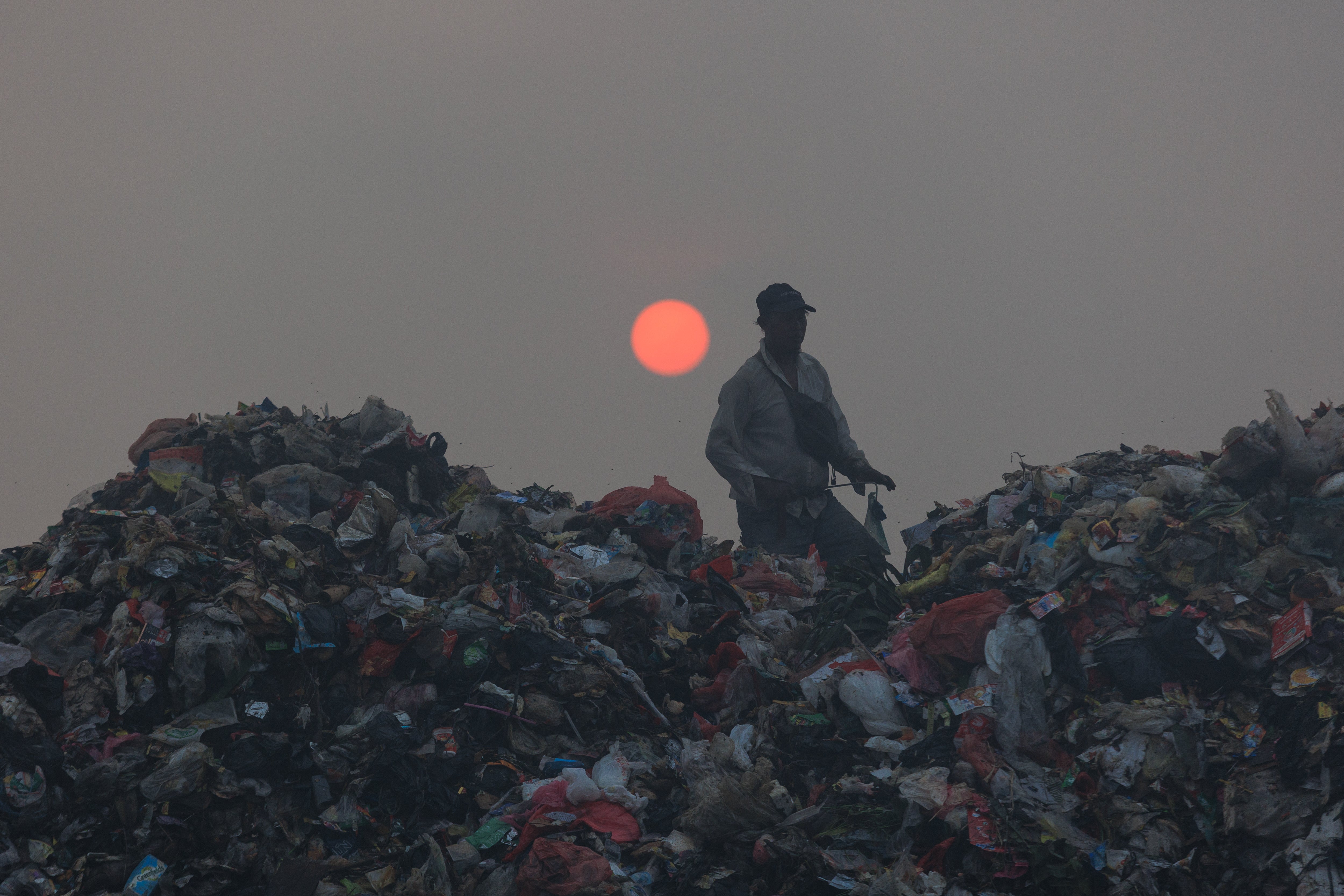 A ragpicker sorts through garbage as smoke billows from a fire at the Jatiwaringin landfill in Tangerang (AFP/Getty)