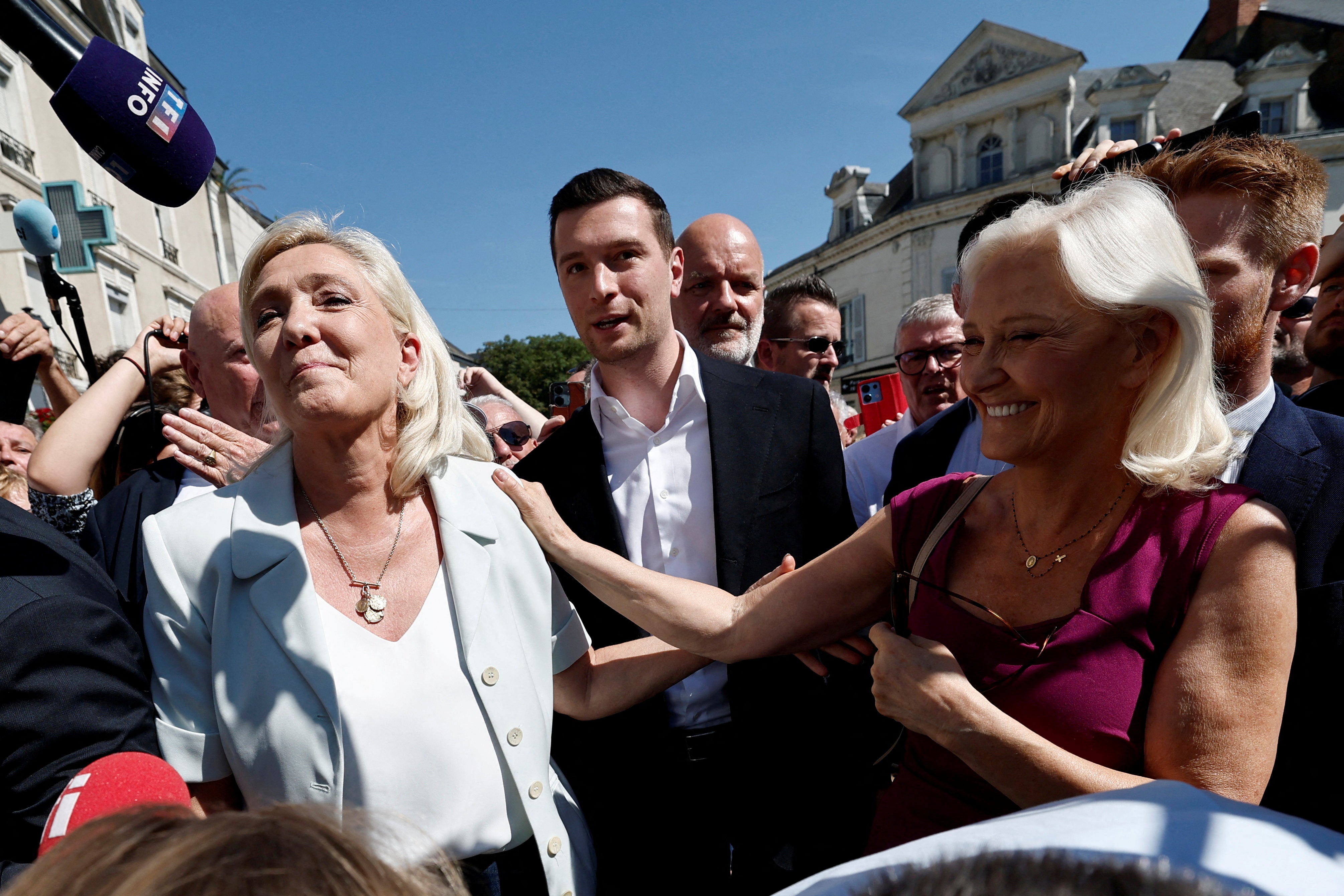 Marine Le Pen, Jordan Bardella, and Marie-Caroline Le Pen, her sister and RN delegate for Sarthe, visit a market in La Fleche on 8 July (Reuters)