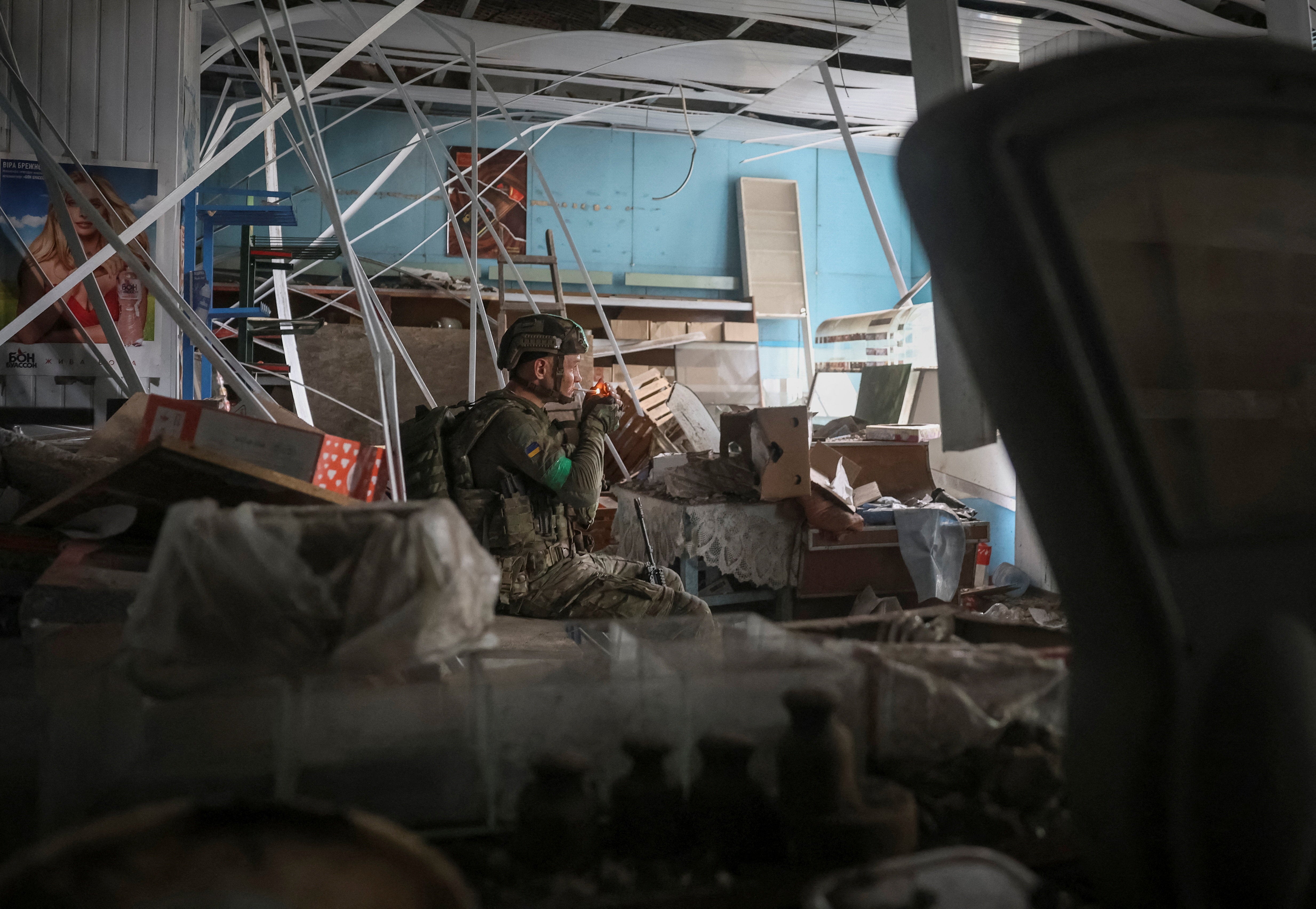 A serviceman of the 49th Separate Assault Battalion Carpathian Sich of the Ukrainian Armed Forces rests inside a damaged store during his combat mission, amid Russia's attack on Ukraine, in the frontline town of Druzhkivka, in Donetsk region, Ukraine July 9, 2026