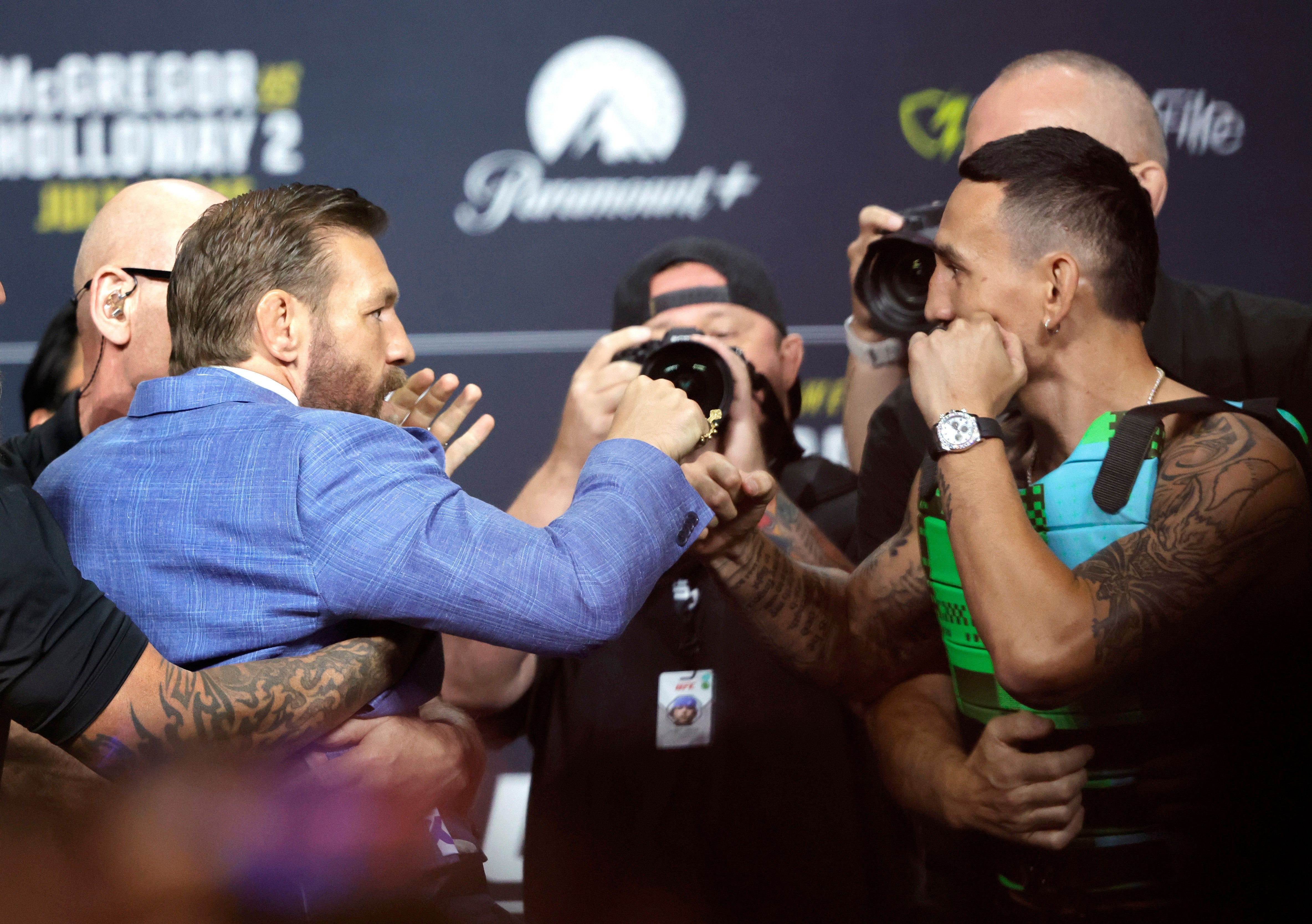 Conor McGregor (left) and Max Holloway pulled apart by security at their press conference