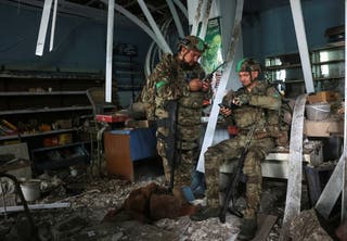 Servicemen of the 49th Separate Assault Battalion Carpathian Sich of the Ukrainian Armed Forces use a drone detector as they hide inside a damaged store during their combat mission, amid Russia's attack on Ukraine, in the frontline town of Druzhkivka, in Donetsk region, Ukraine July 9, 2026.