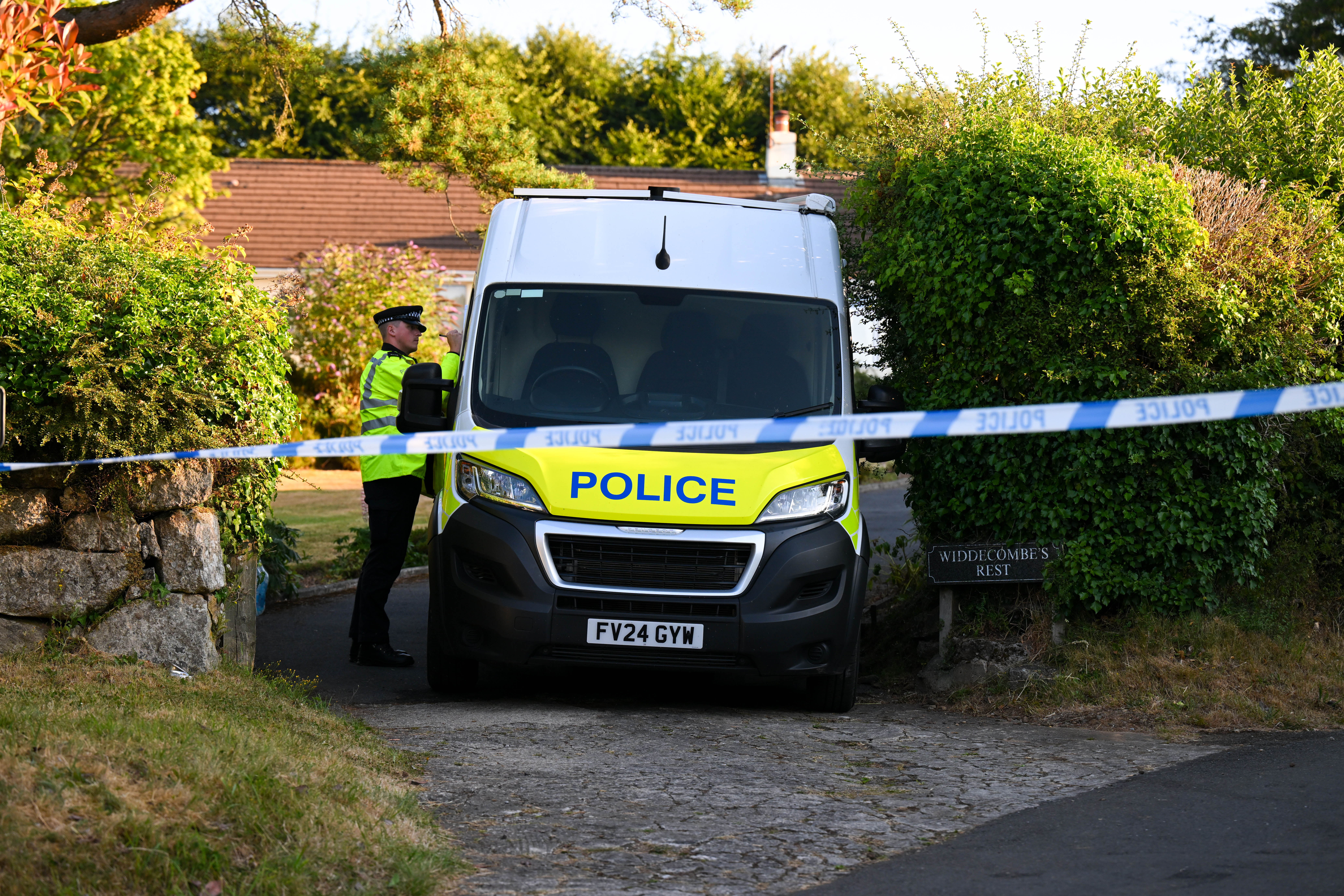 A police officer stands outside the house of Ann Widdecombe in Haytor on July 11