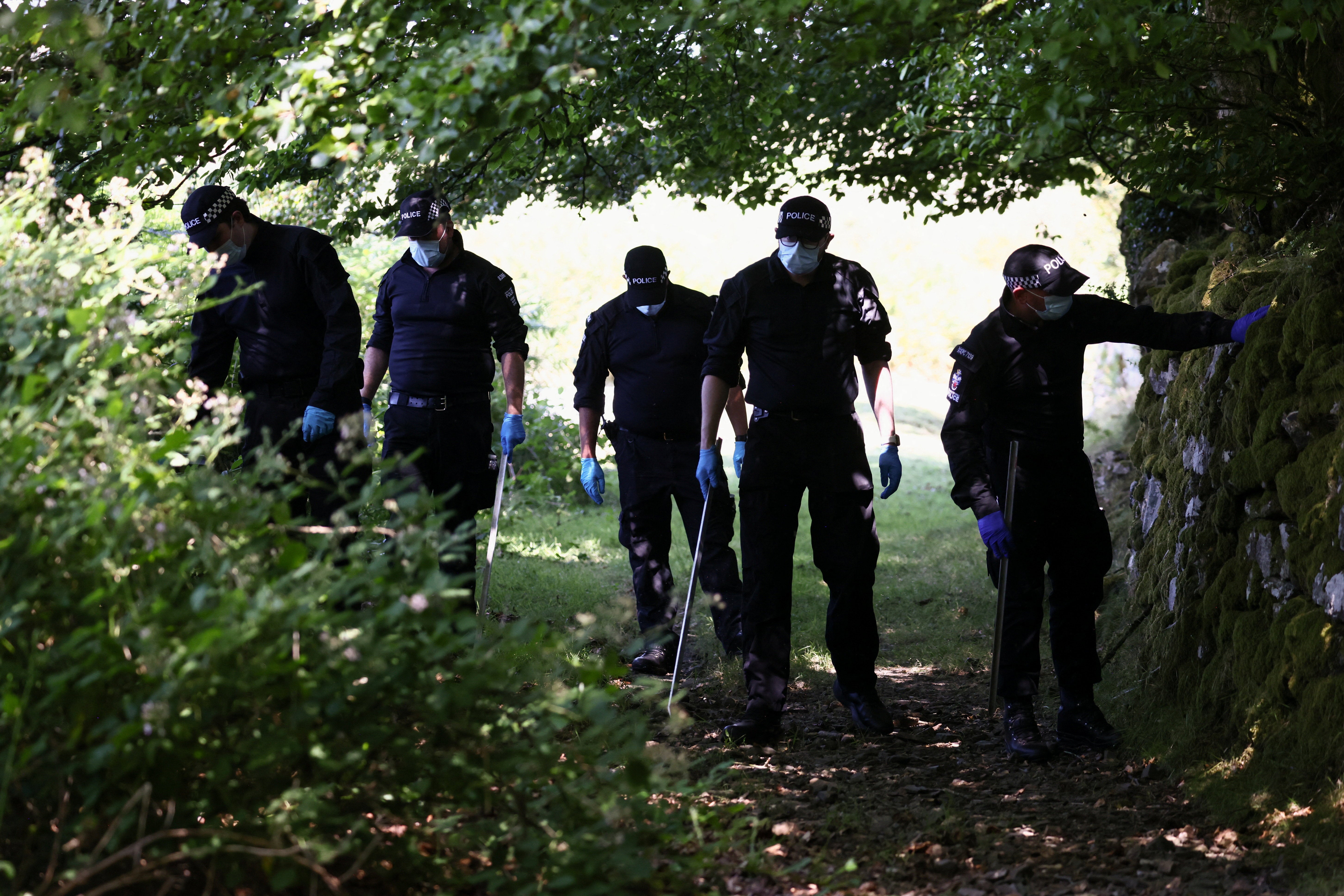 Police officers investigate the area near the home of Ann Widdecombe on Saturday