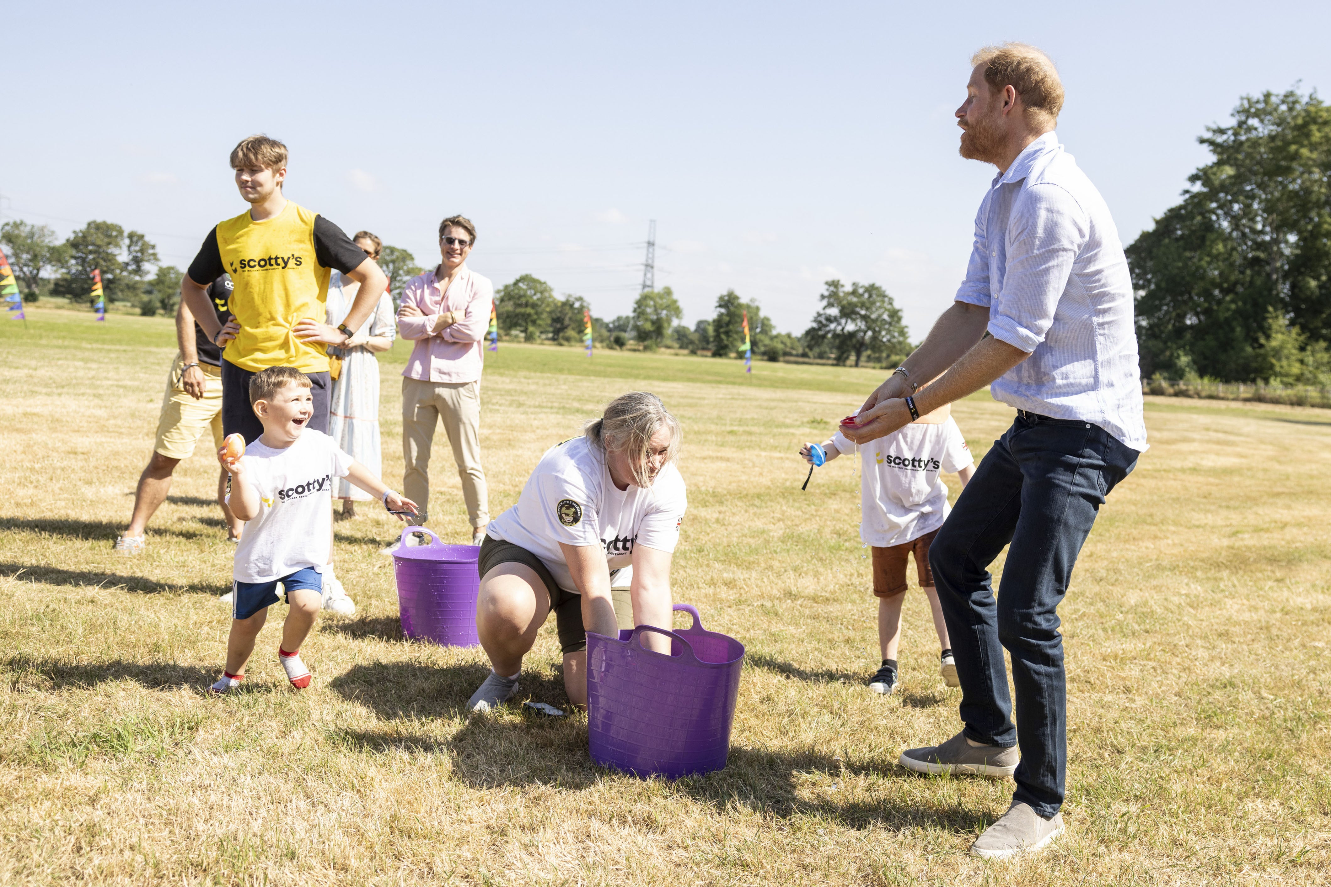 Harry dodged water balloons thrown by the children (PA)