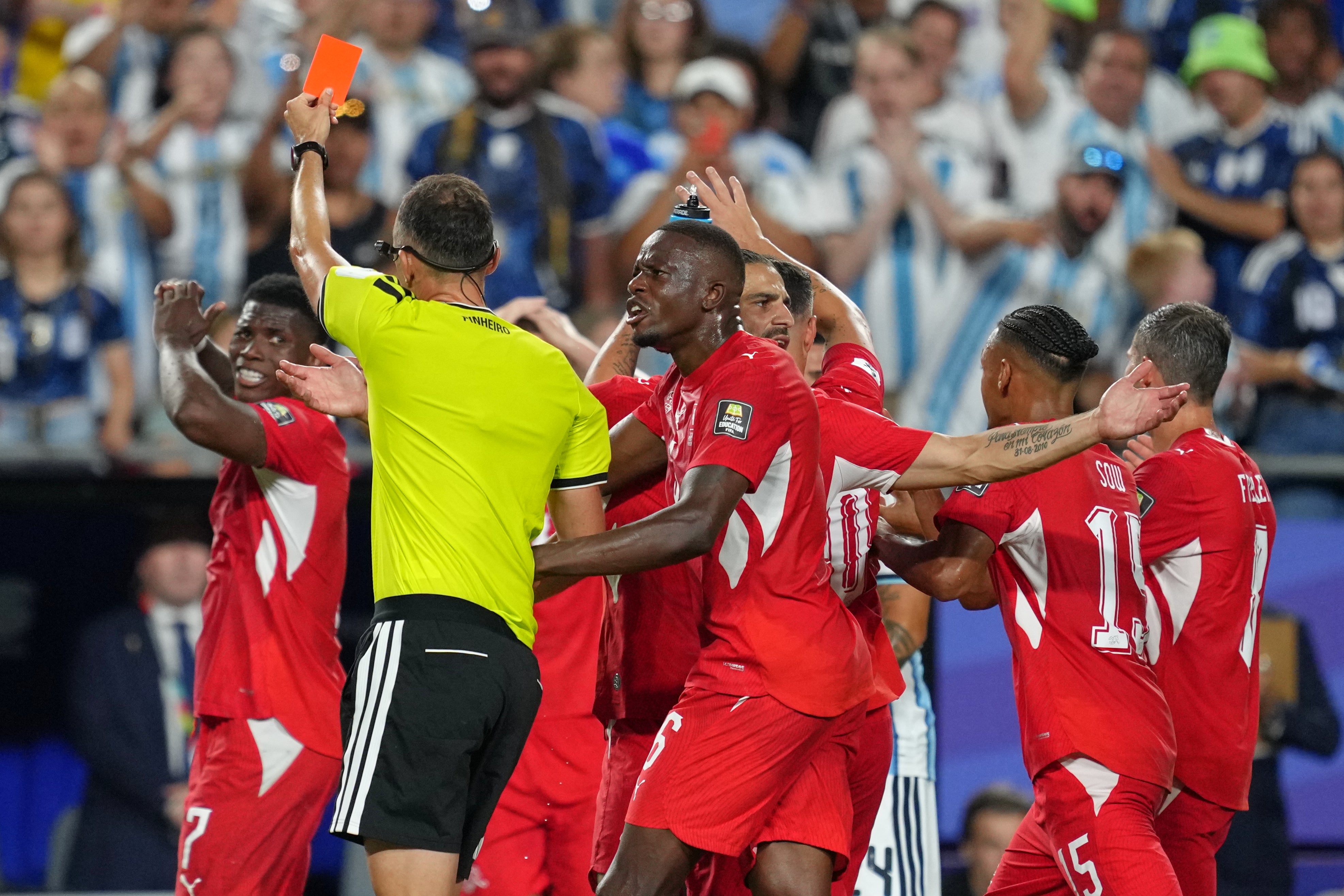 Referee Joao Pinheiro, of Portugal, gives a red card to Switzerland's Breel Embolo