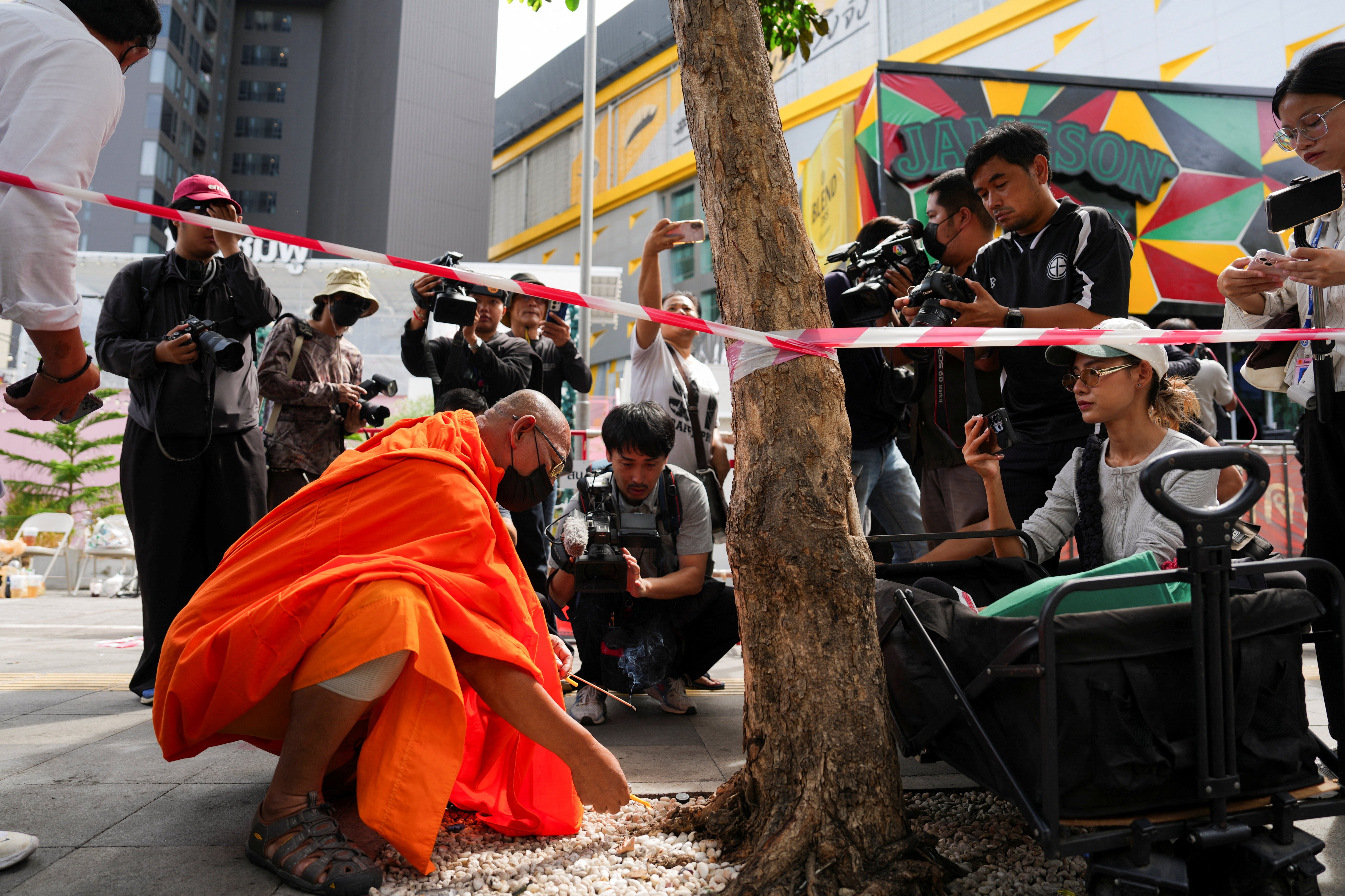 A Buddhist monk prays at the site of a deadly fire at a pub in Bangkok, Thailand