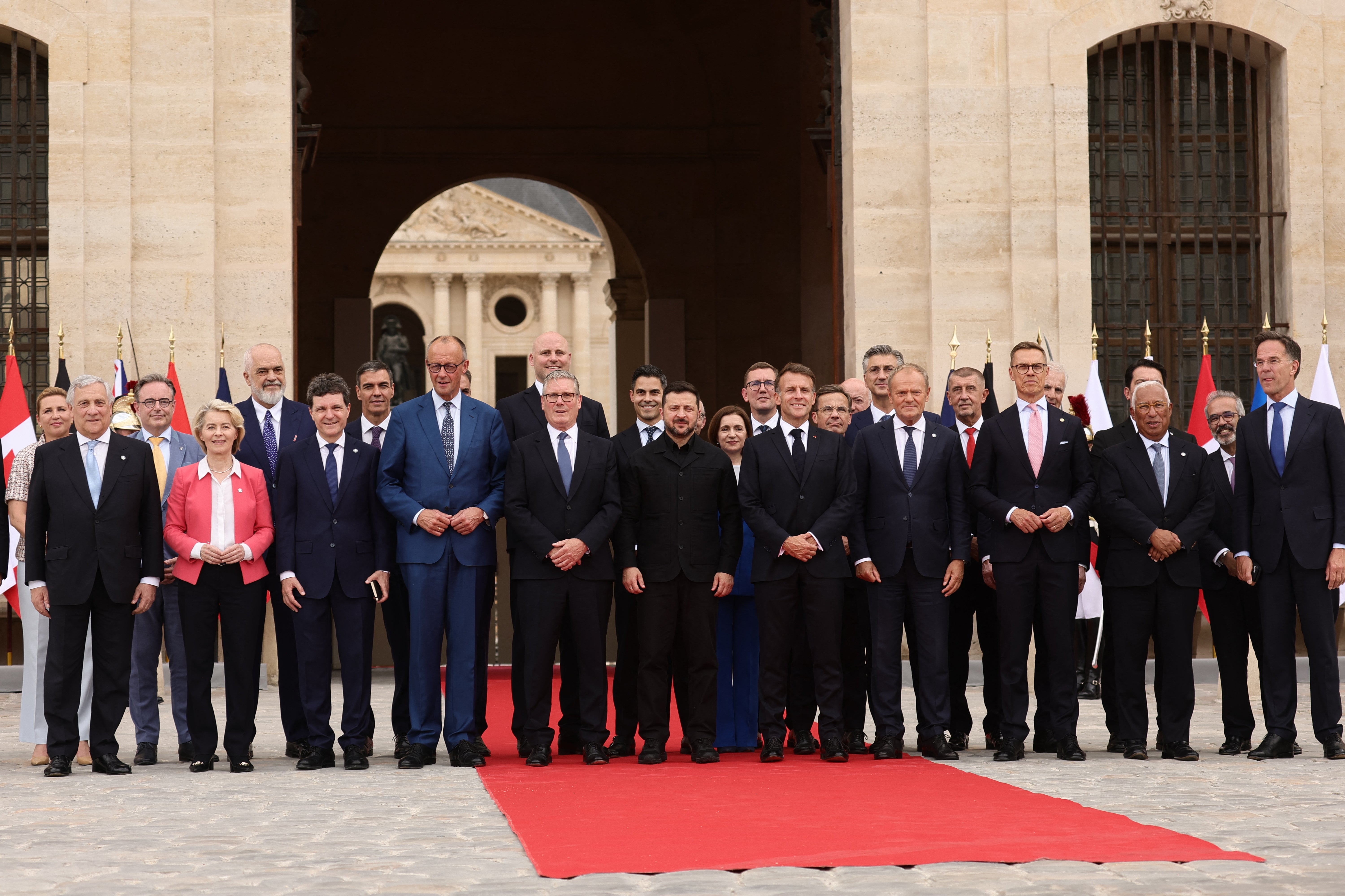 French President Emmanuel Macron (C-L) and Ukrainian President Volodymyr Zelensky (C) pose for a family picture with heads of states and governments before a summit of the Coalition of the Willing to support Ukraine at the Hotel des Invalides in Paris on July 13, 2026.
