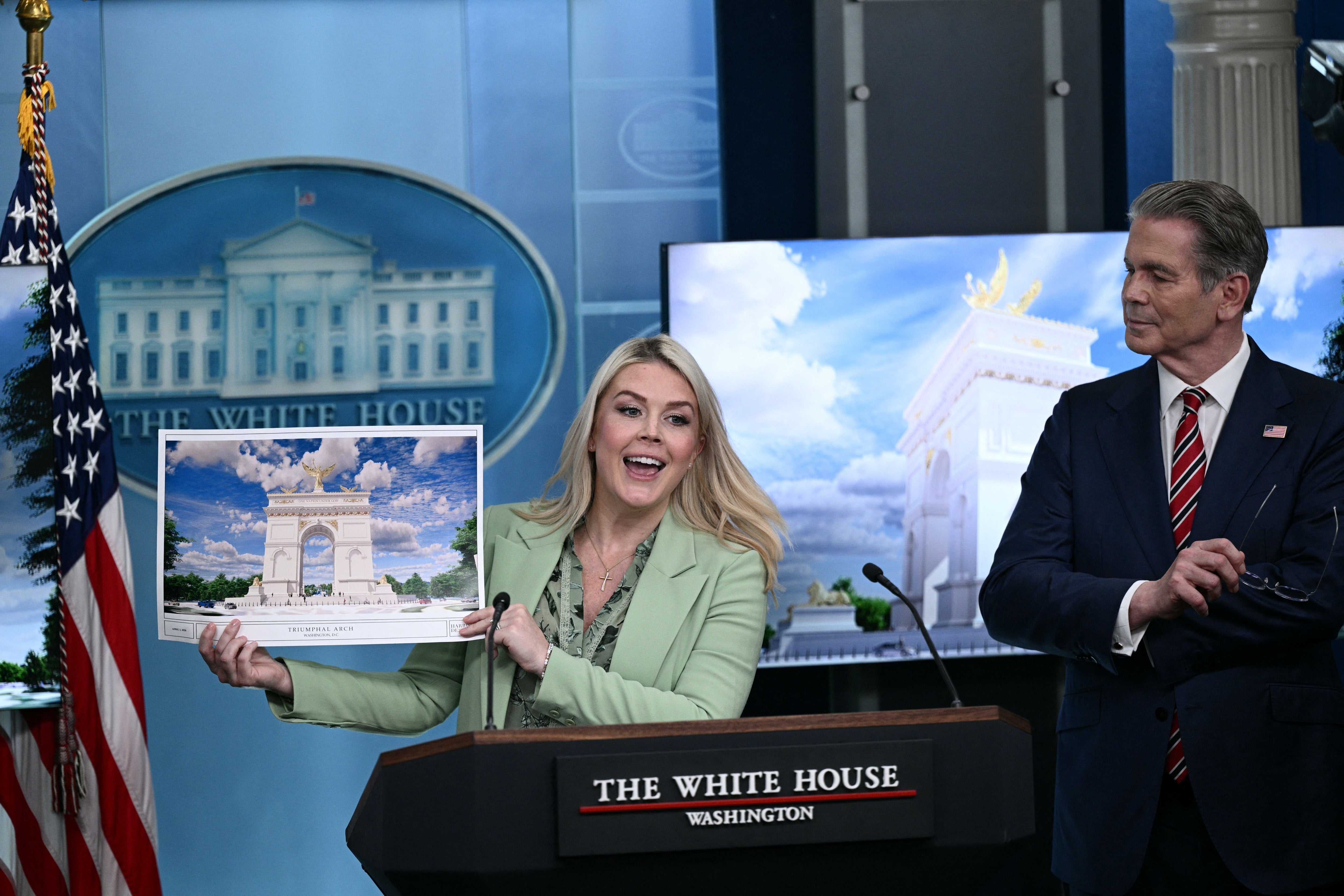 Secretary of Treasury Scott Bessent looks on as White House Press Secretary Karoline Leavitt shows an artist's rendering of Trump's planned arch, which would tower over all DC structures.
