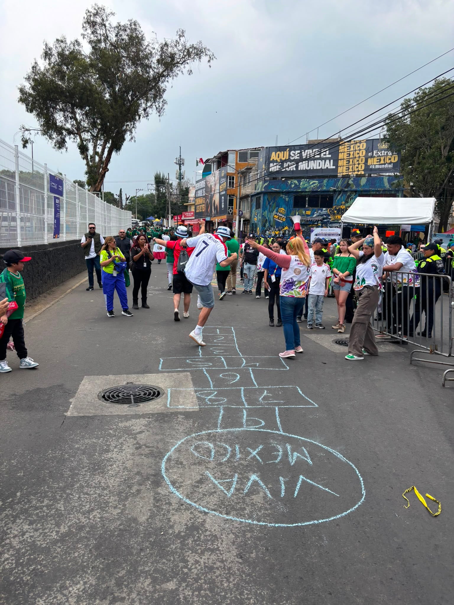 Two England fans play hop-scotch with Mexican locals outside the Estadio Azteca