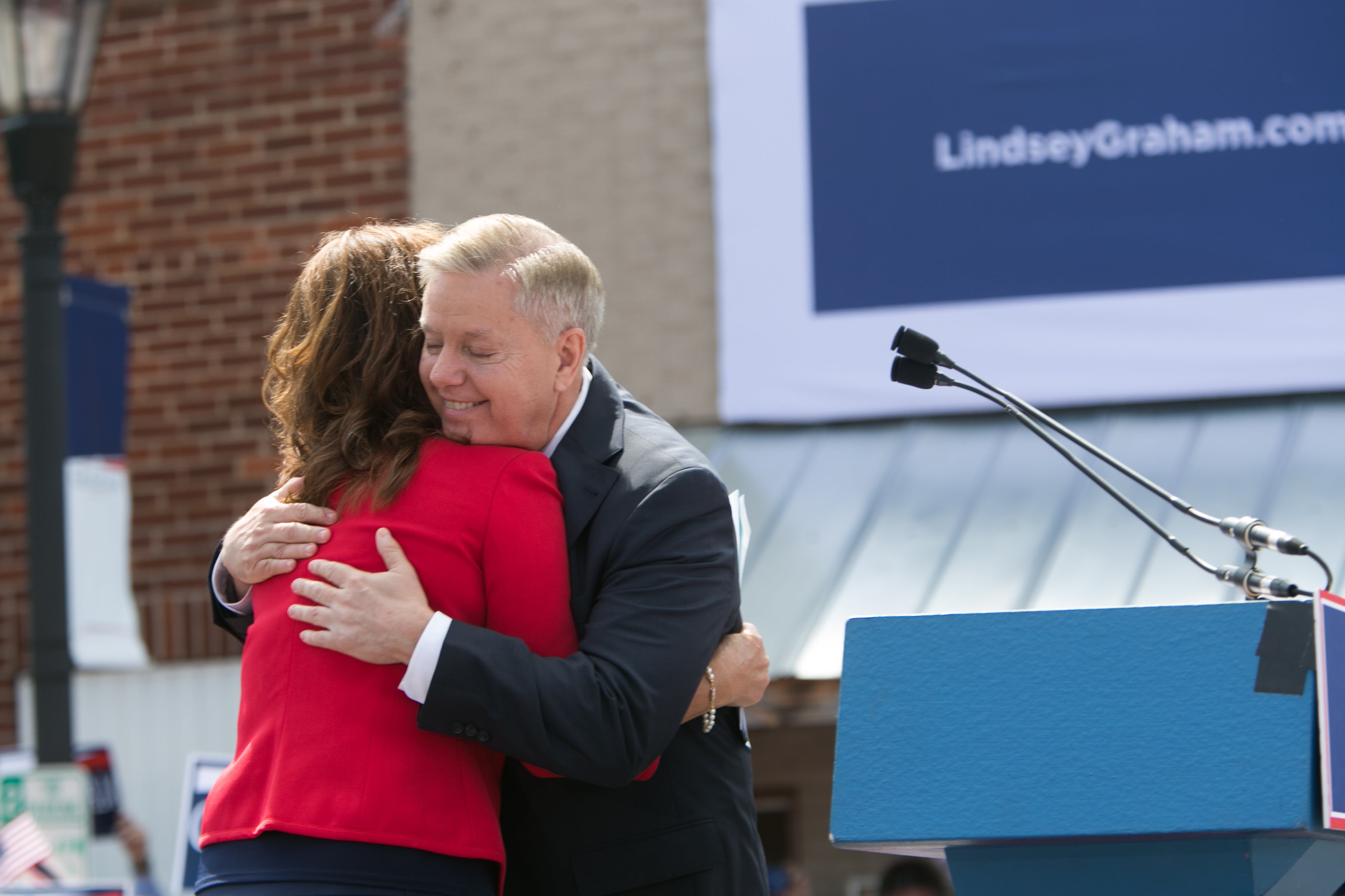 Lindsey Graham (R-SC) hugs is sister Darline Graham Nordone on stage as he announces his candidacy for United States President during an outdoor event for supporters on June 1, 2015