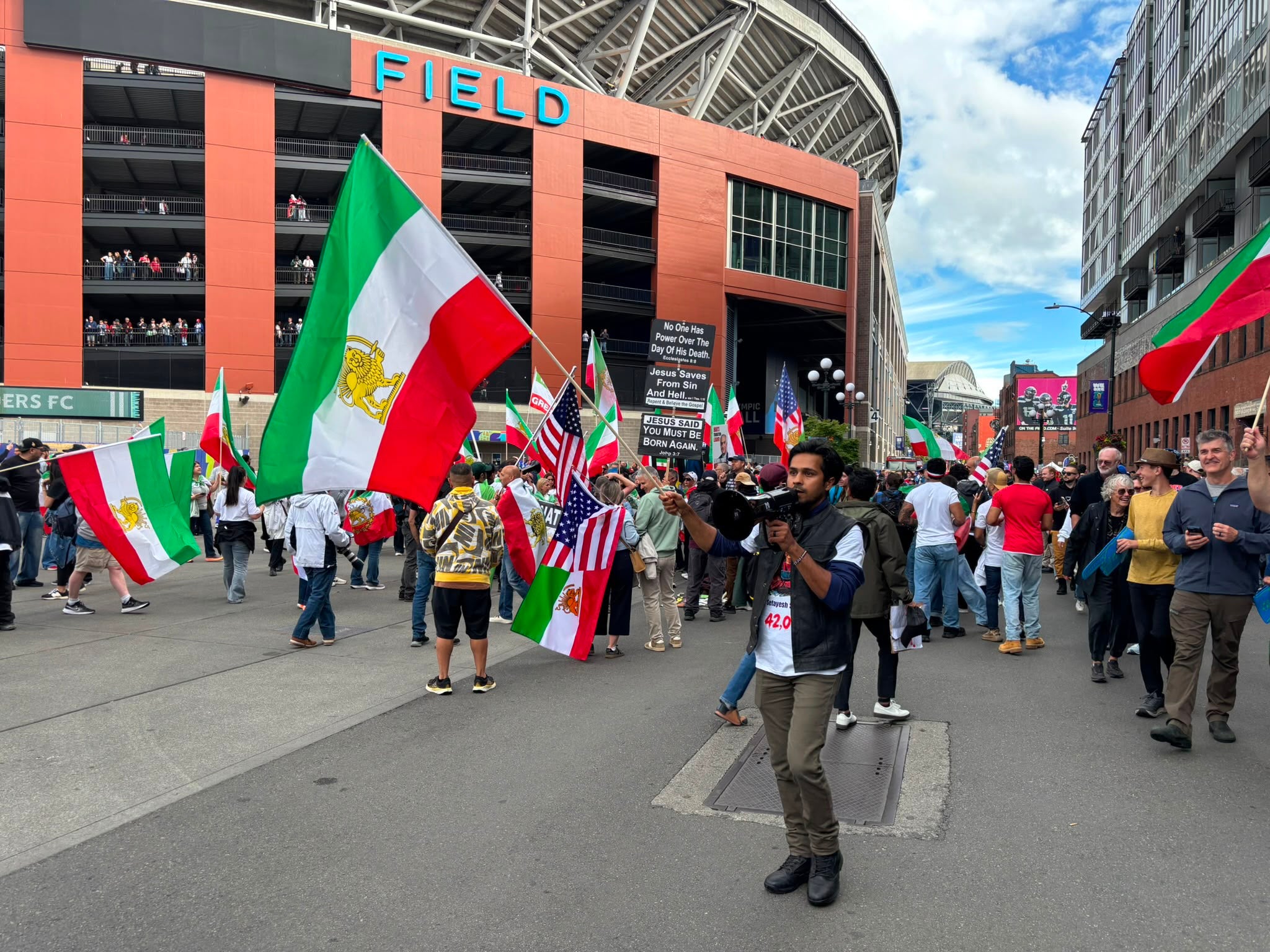 Emery, 37, an anti-Iranian regime campaigner, holding a microphone outside Lumen Field