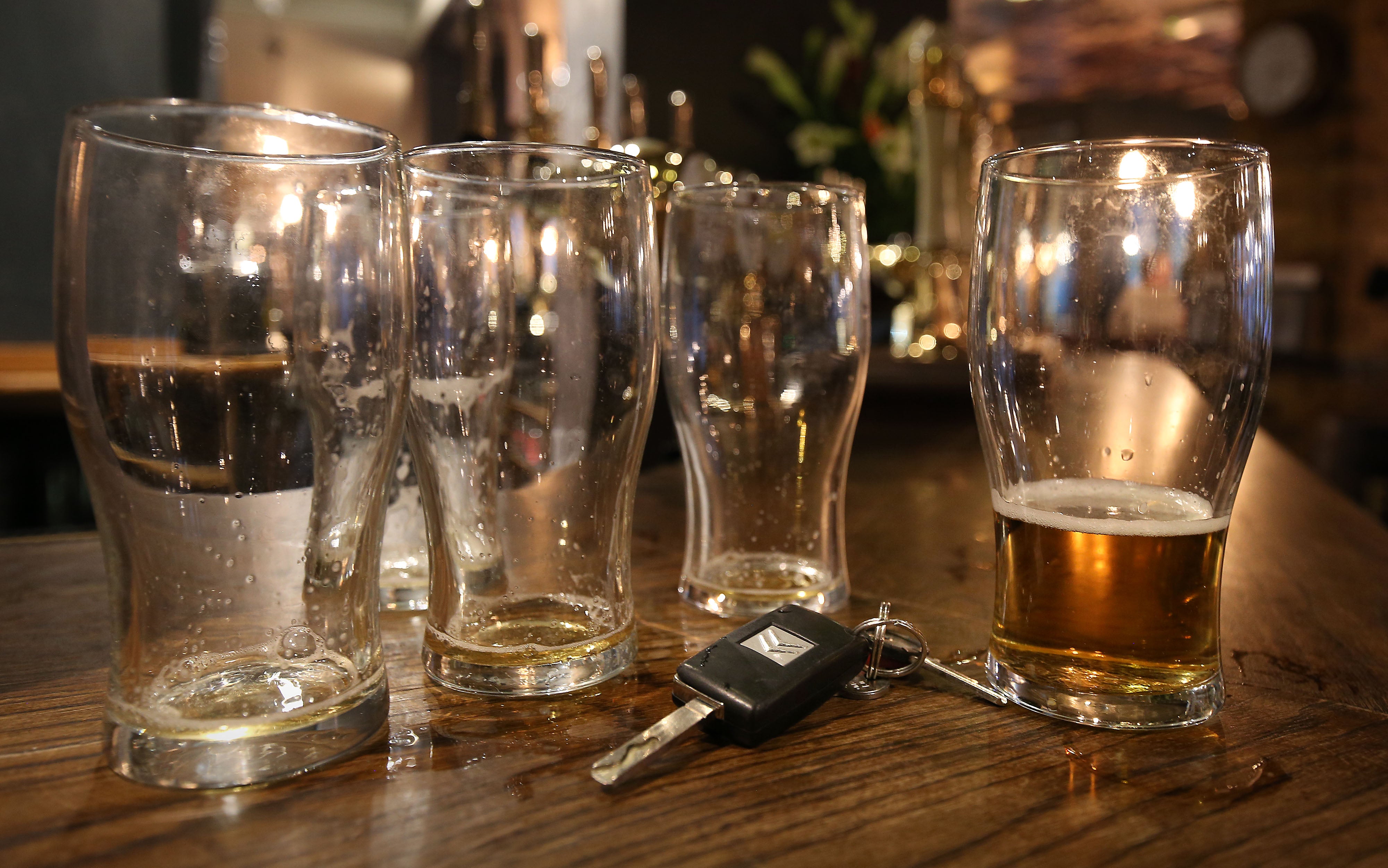 Beer glasses and a set of car keys on a bar in a pub in central London