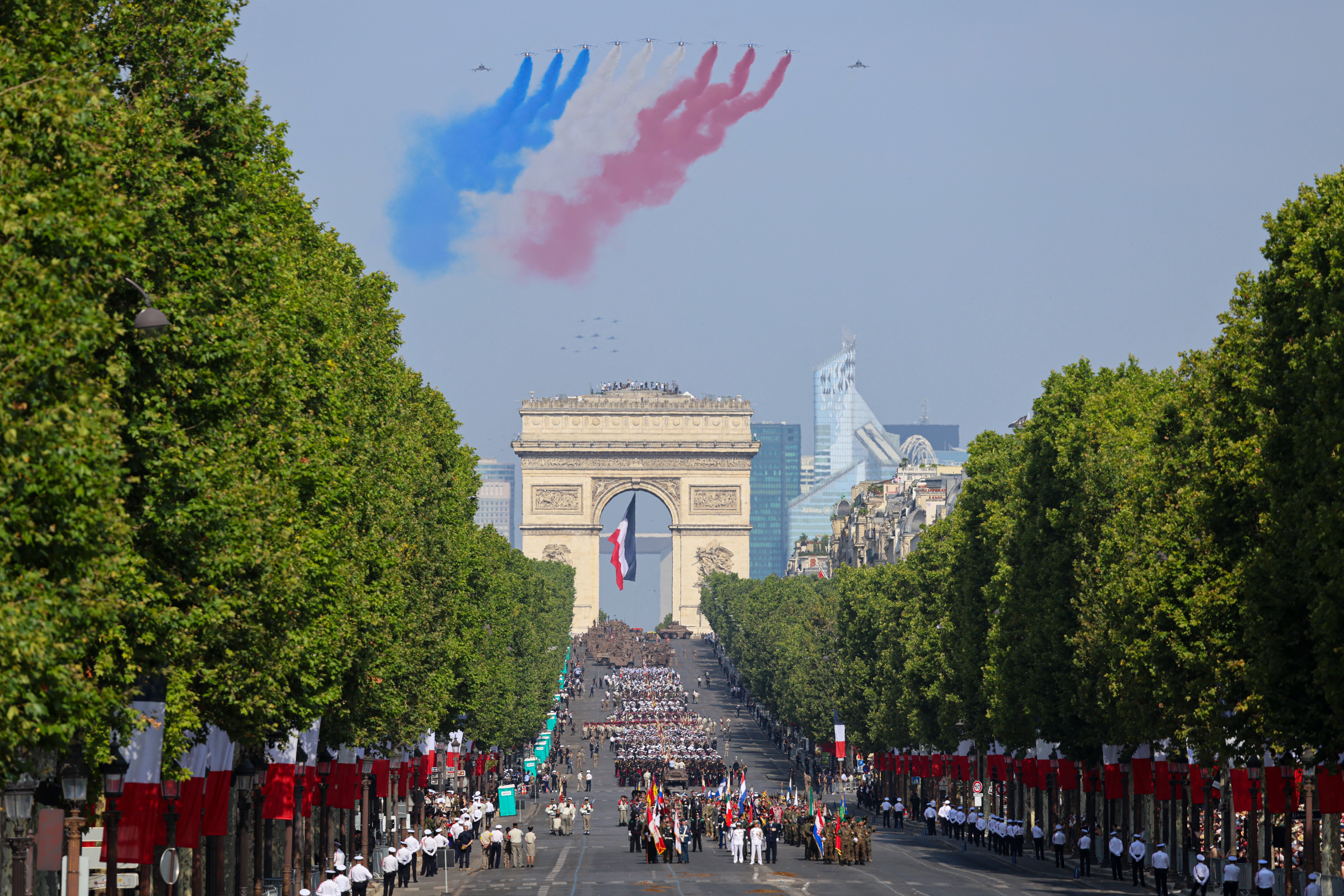 France's Air Force Elite aerobatic flying team "Patrouille de France" (PAF) releases trails of France's national colours as they perform a flyover during the annual Bastille Day military parade on the Champs-Elysees Avenue