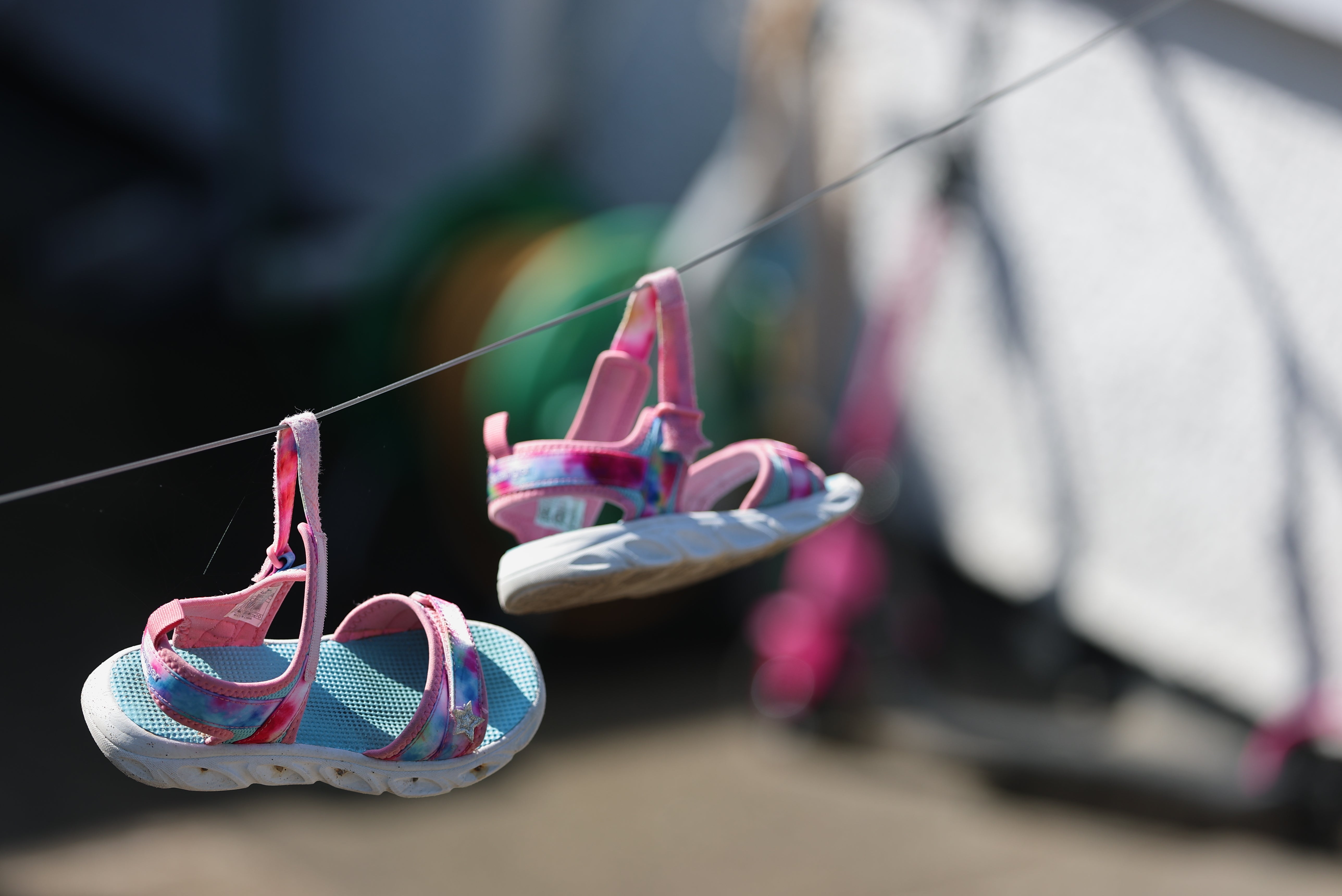 A pair of child’s sandals on a washing line at the scene in the Old Cullybackey Road area of Ballymena, Co Antrim (Liam McBurney/PA) (PA Wire)