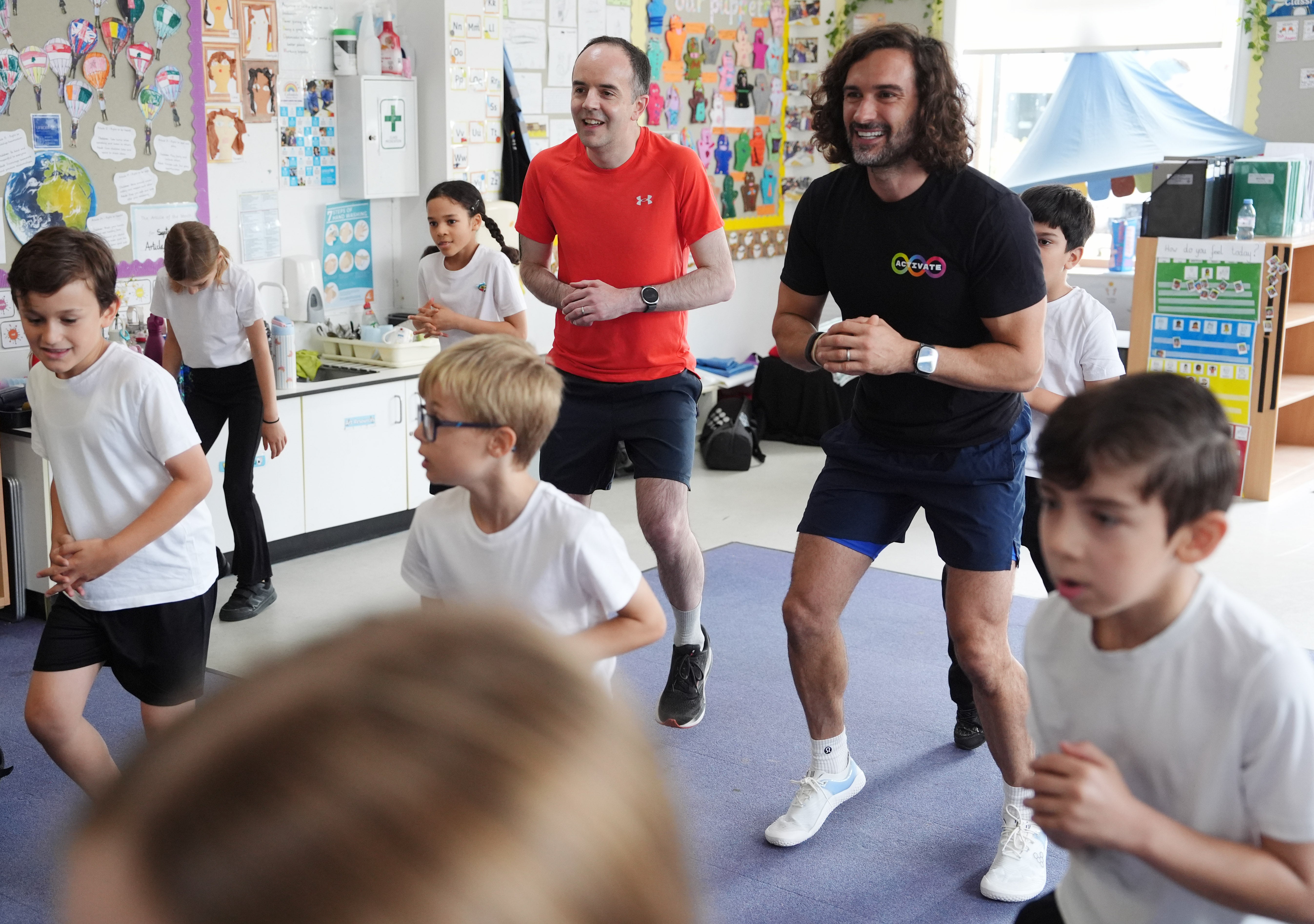 Joe Wicks and Health Secretary James Murray meet and exercise with year 2 and 3 pupils during a visit to Colindale Primary School in London to launch the fitness coach’s new series of kids’ workout programme Activate