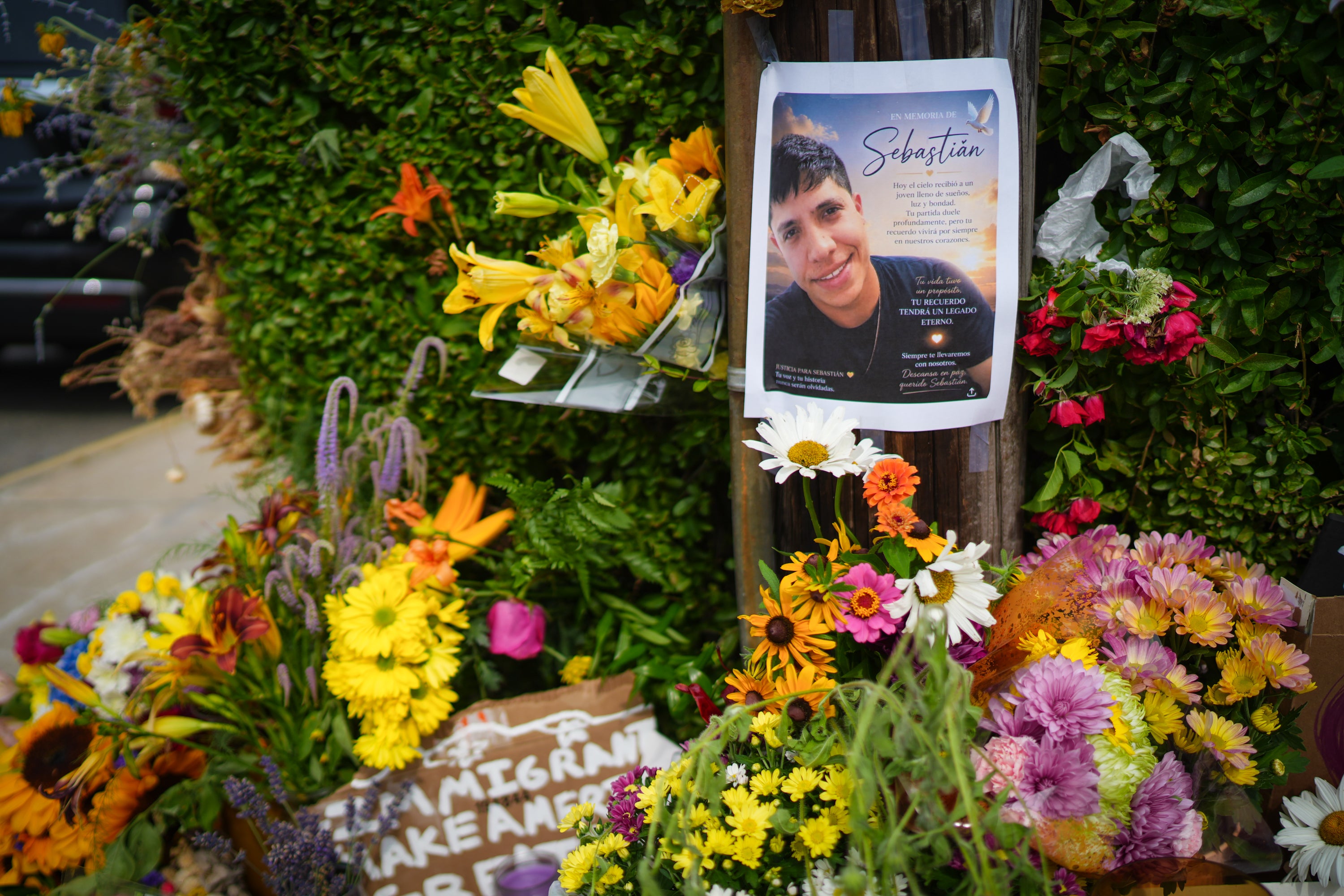 Members of the community left candles, flowers and pro-Immigrant messages at the scene where federal agents shot a Colombian native who was allegedly working in the US lawfully (Getty)
