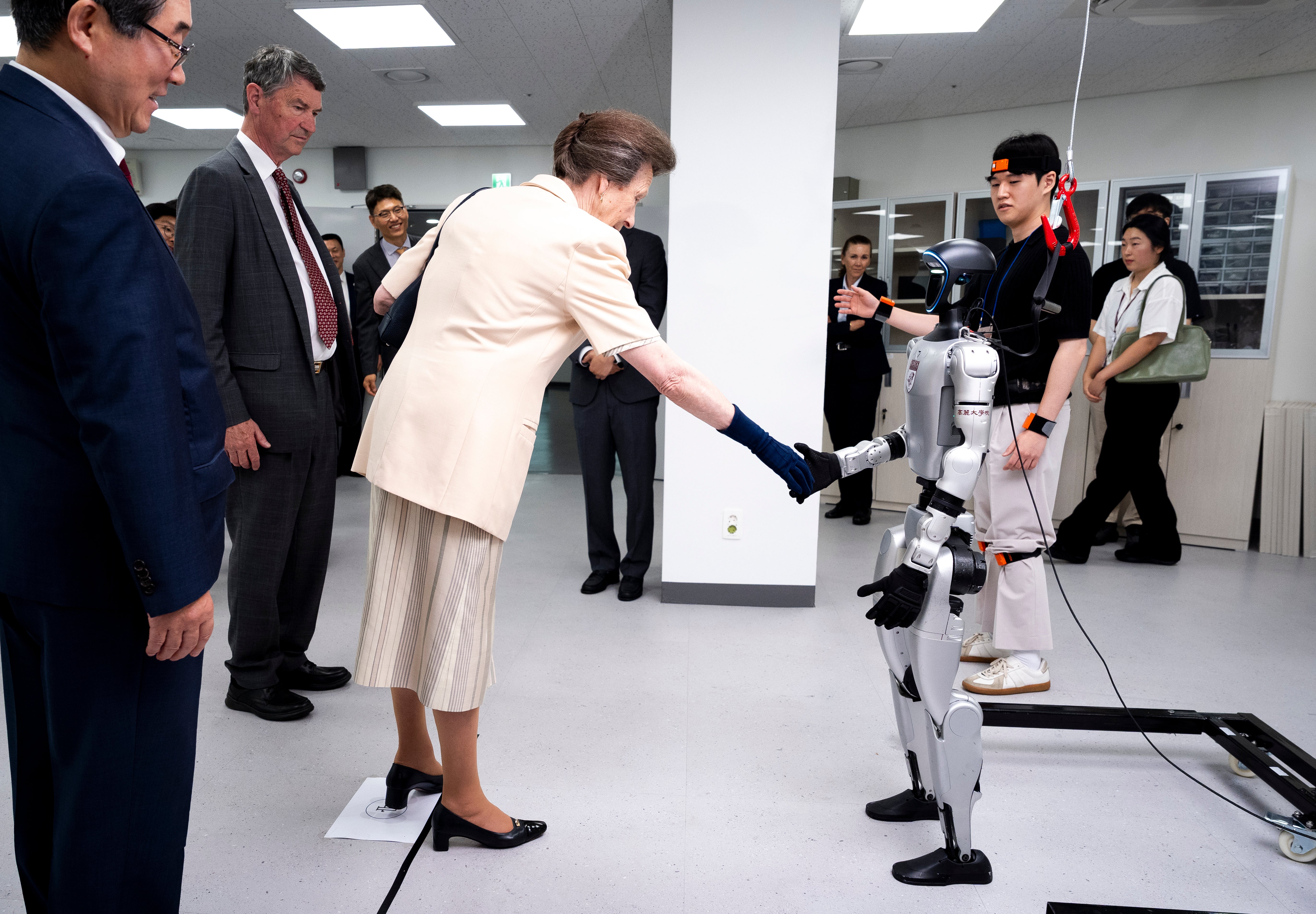 The Princess Royal, accompanied by her husband Vice Admiral Sir Tim Laurence shakes the hand of a robot during a visit to the Jung Woonoh IT & General Education Center on the on the Seoul campus of Korea University (PA)