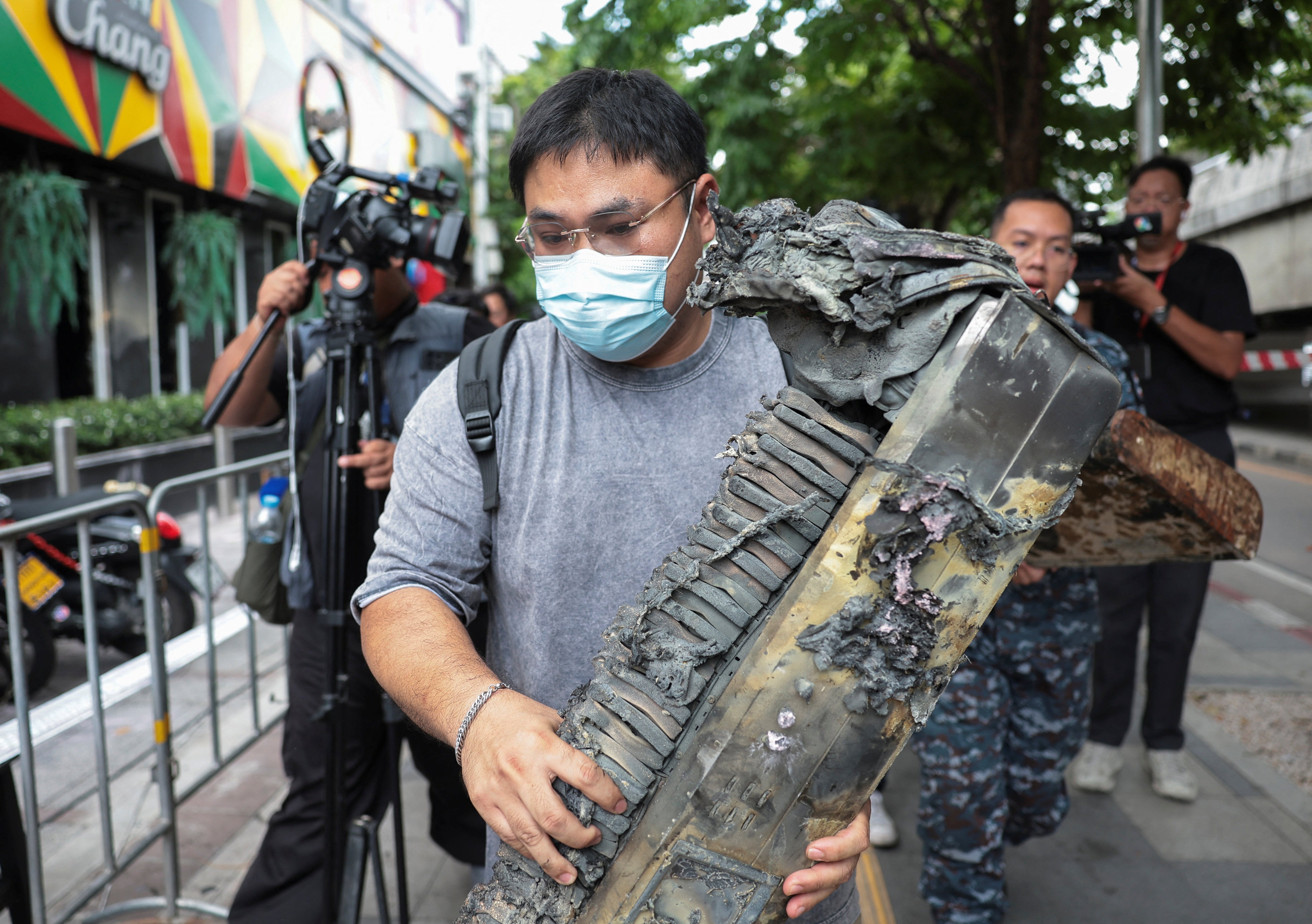 Brother of the victim, Phrutthiphong Phudmon who was a keyboard player of the band playing on the day of the deadly fire, carries Phudmon's music keyboard as he visits Rong Beer Na Lat Phrao bar (Reuters)