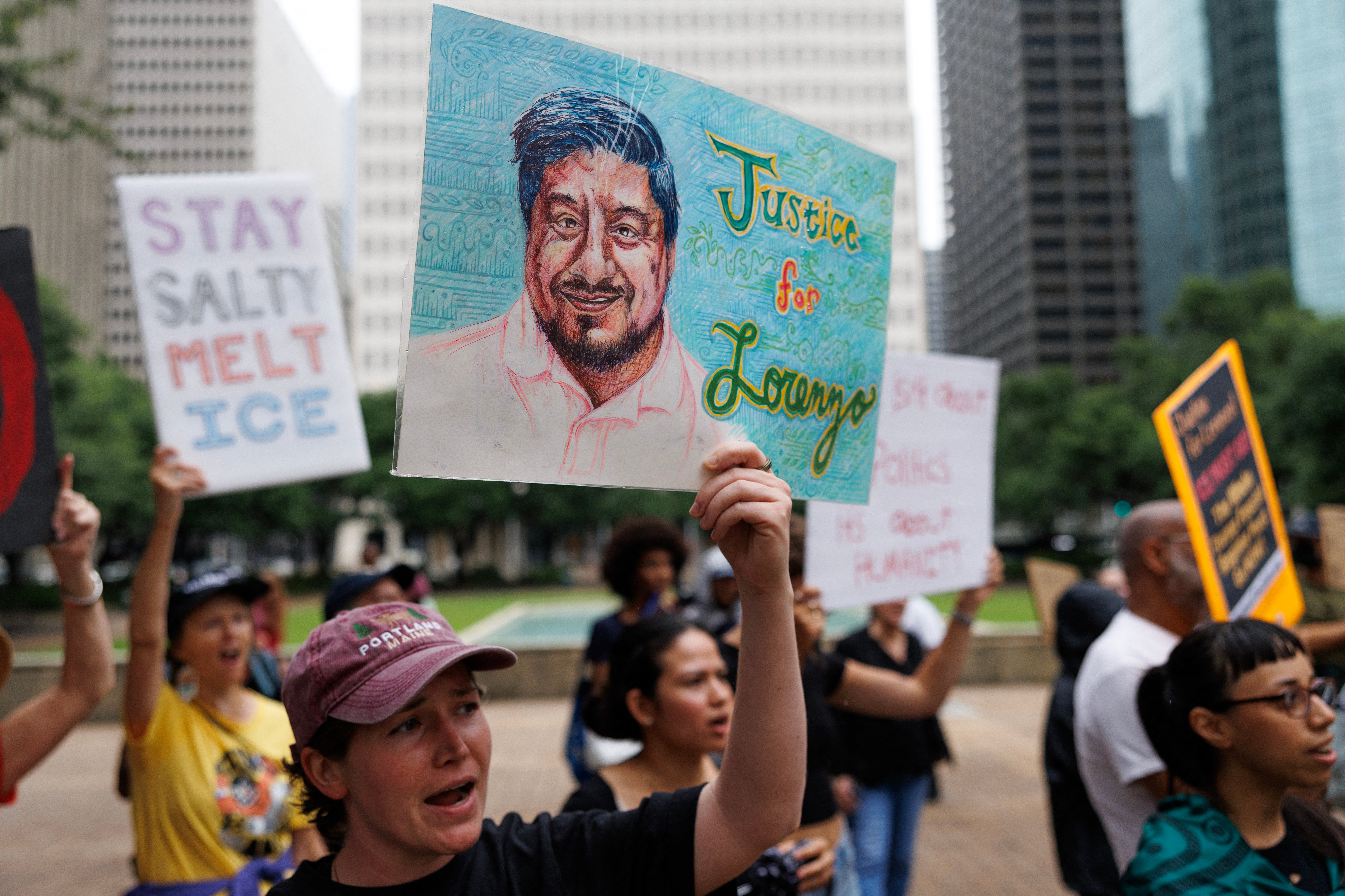 Demonstrators hold up a portait of Lorenzo Salgado Araujo, who was killed by federal agents, at a Tuesday protest outside of City Hall in Houston